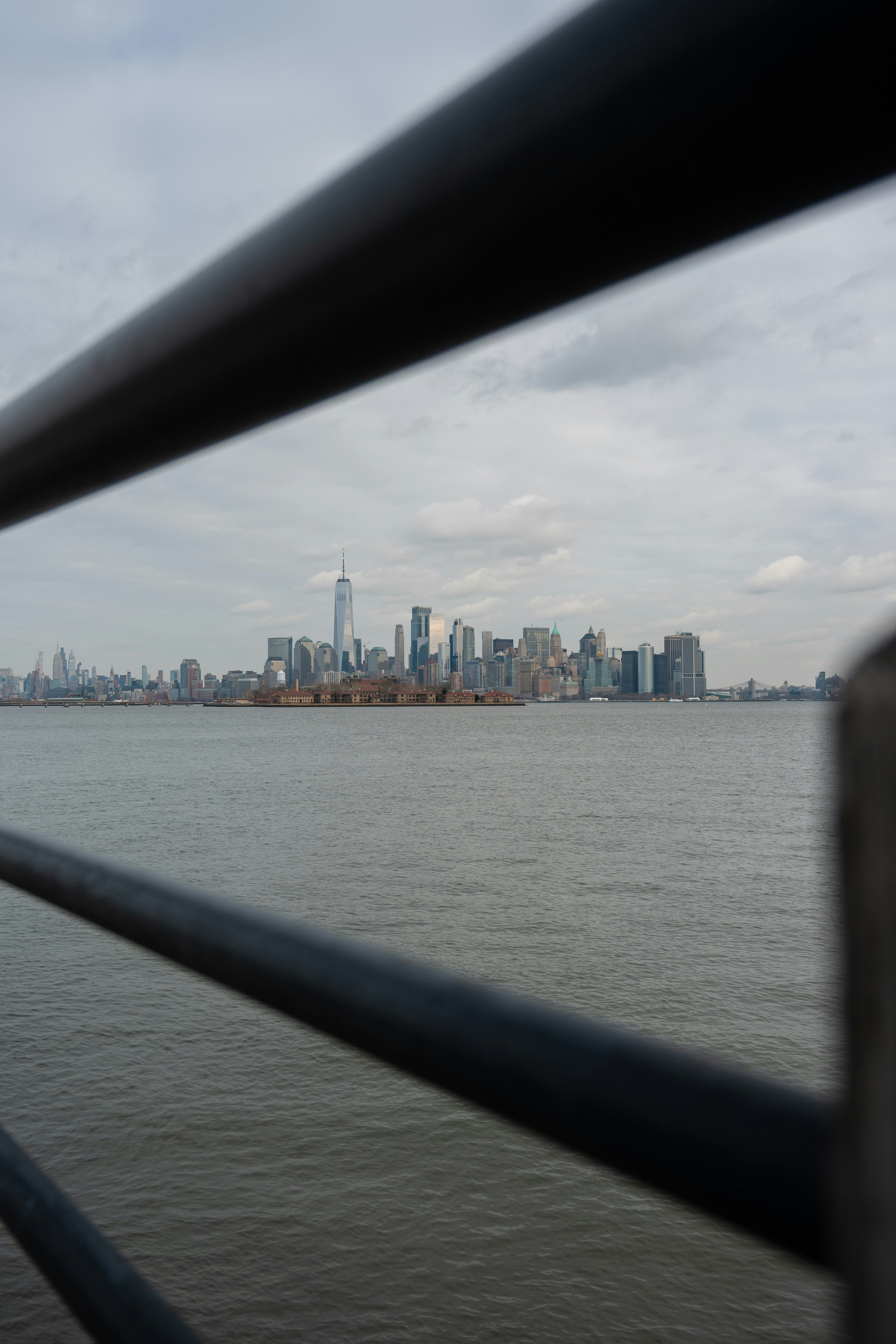 New york city skyline across the water under clouds.
