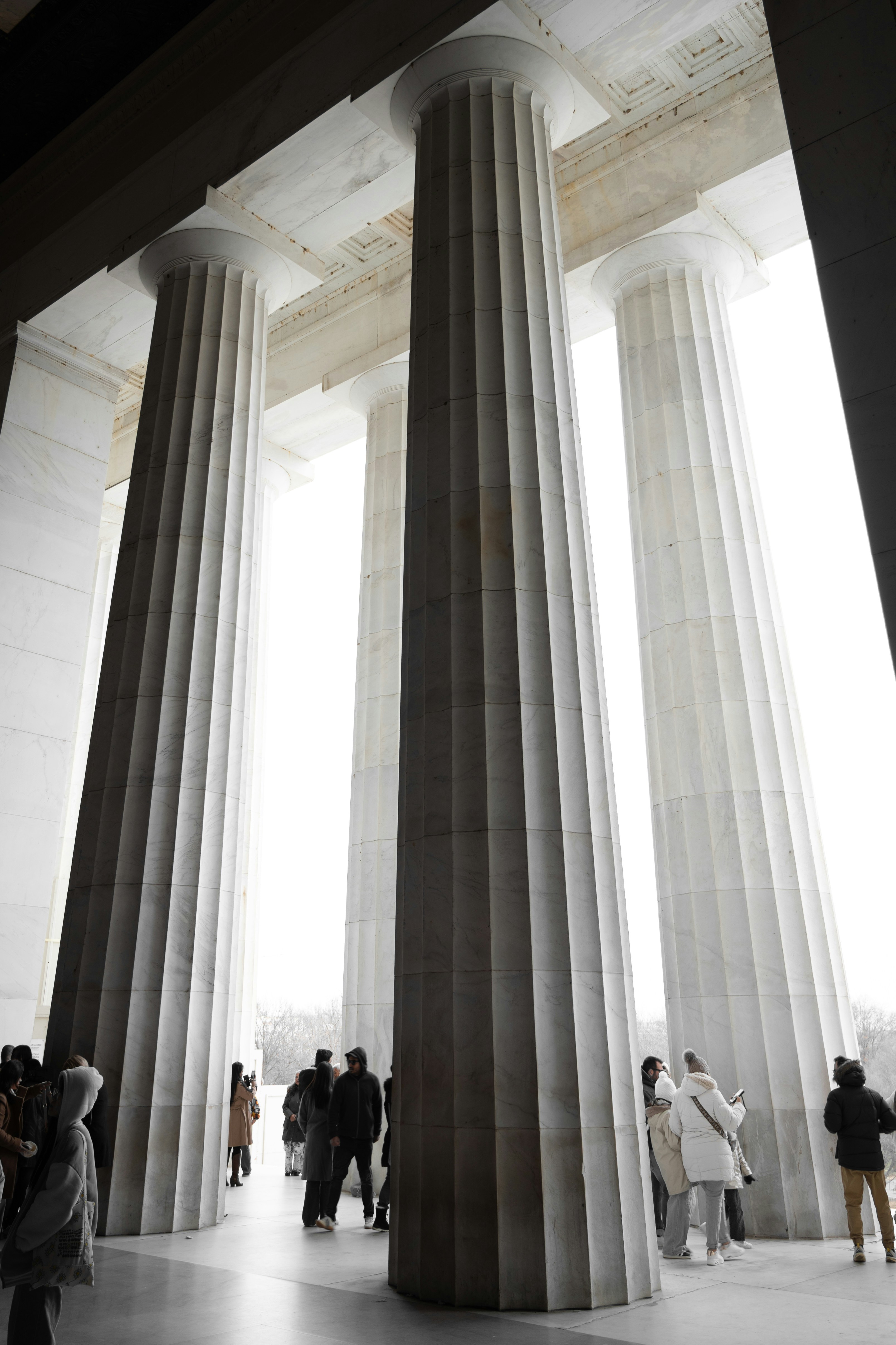 Tall marble columns inside a grand building with people