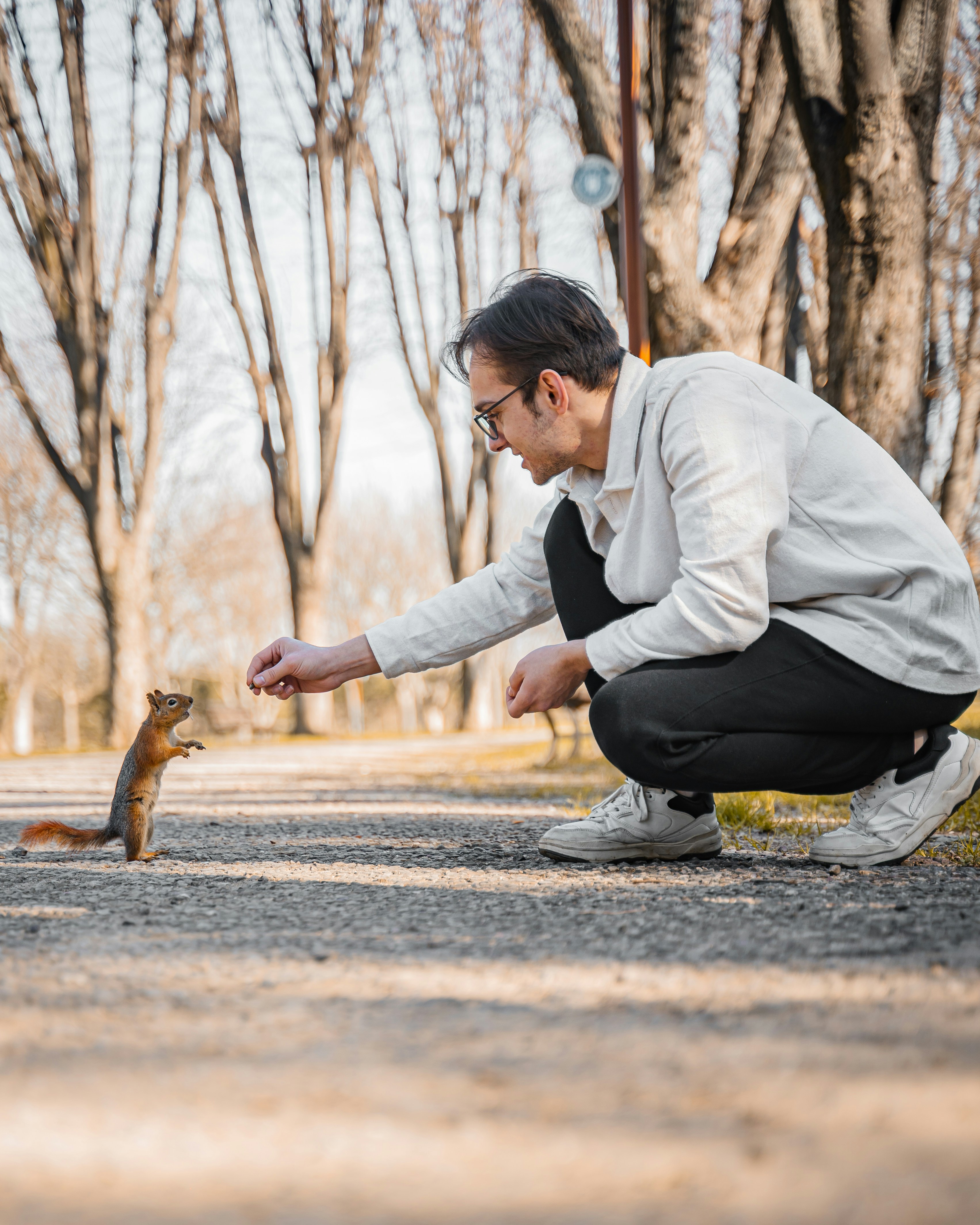 Man feeding a squirrel in a park