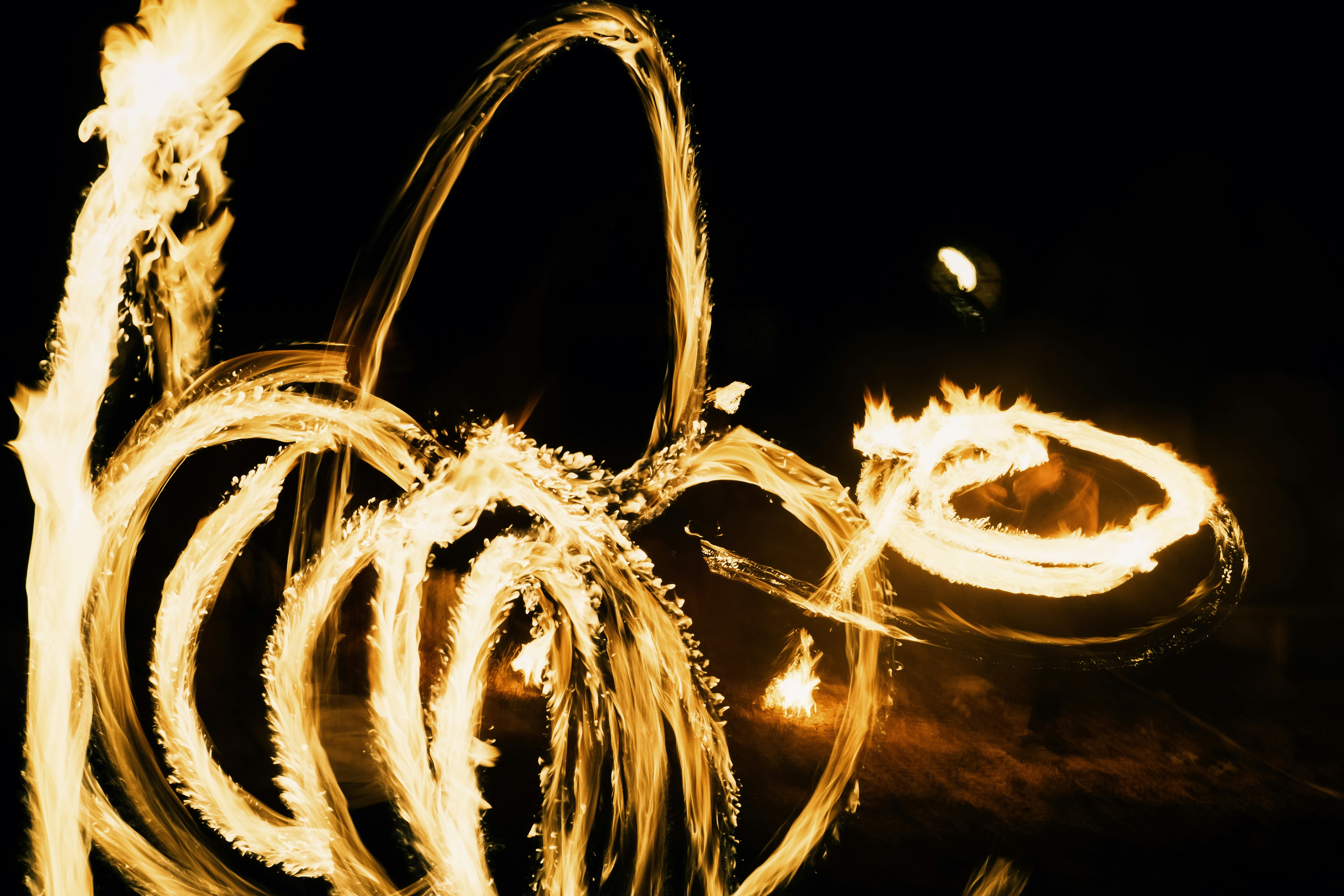 Fire dancer creates glowing light trails at night