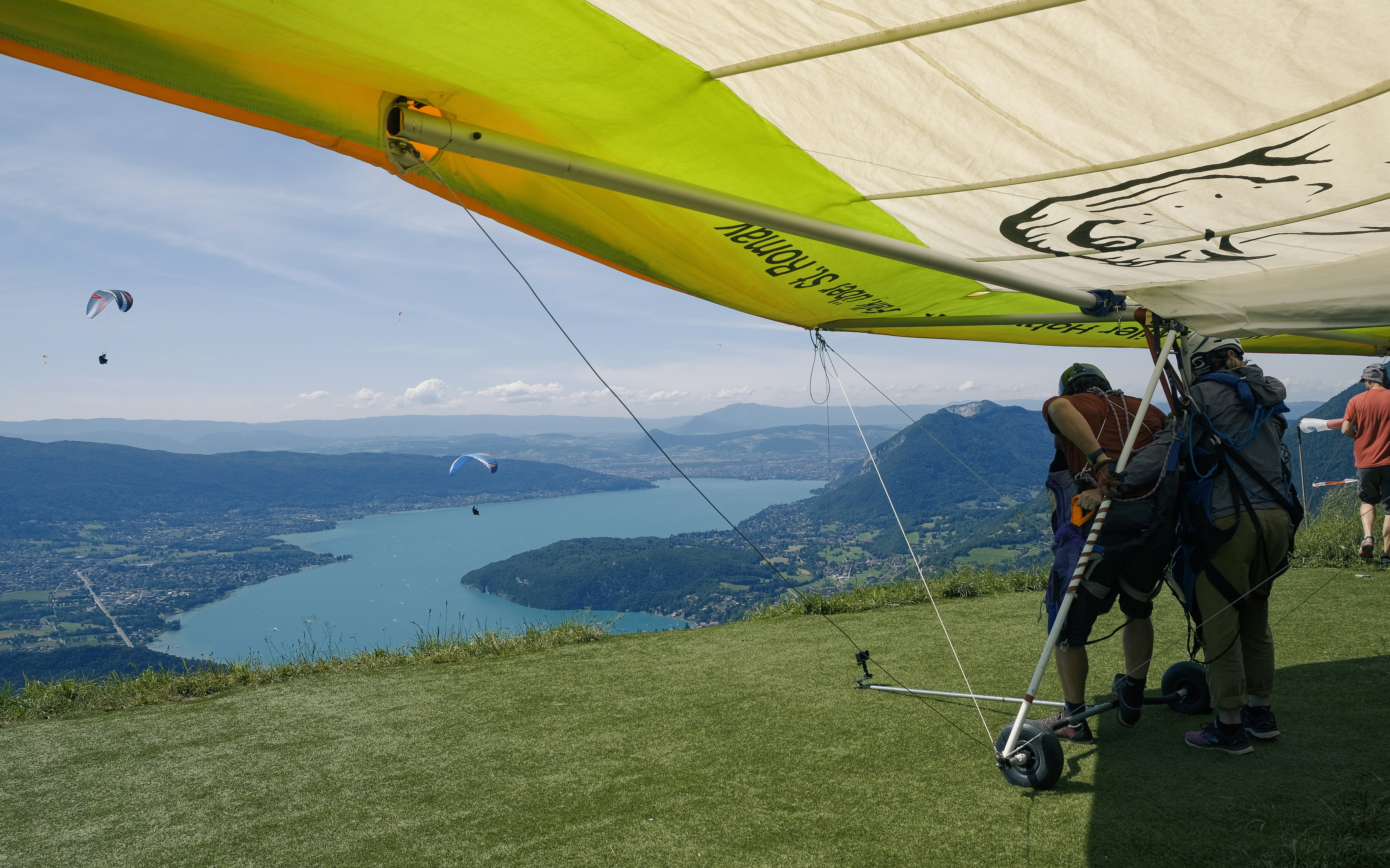 Hang glider preparing for launch above a lake.