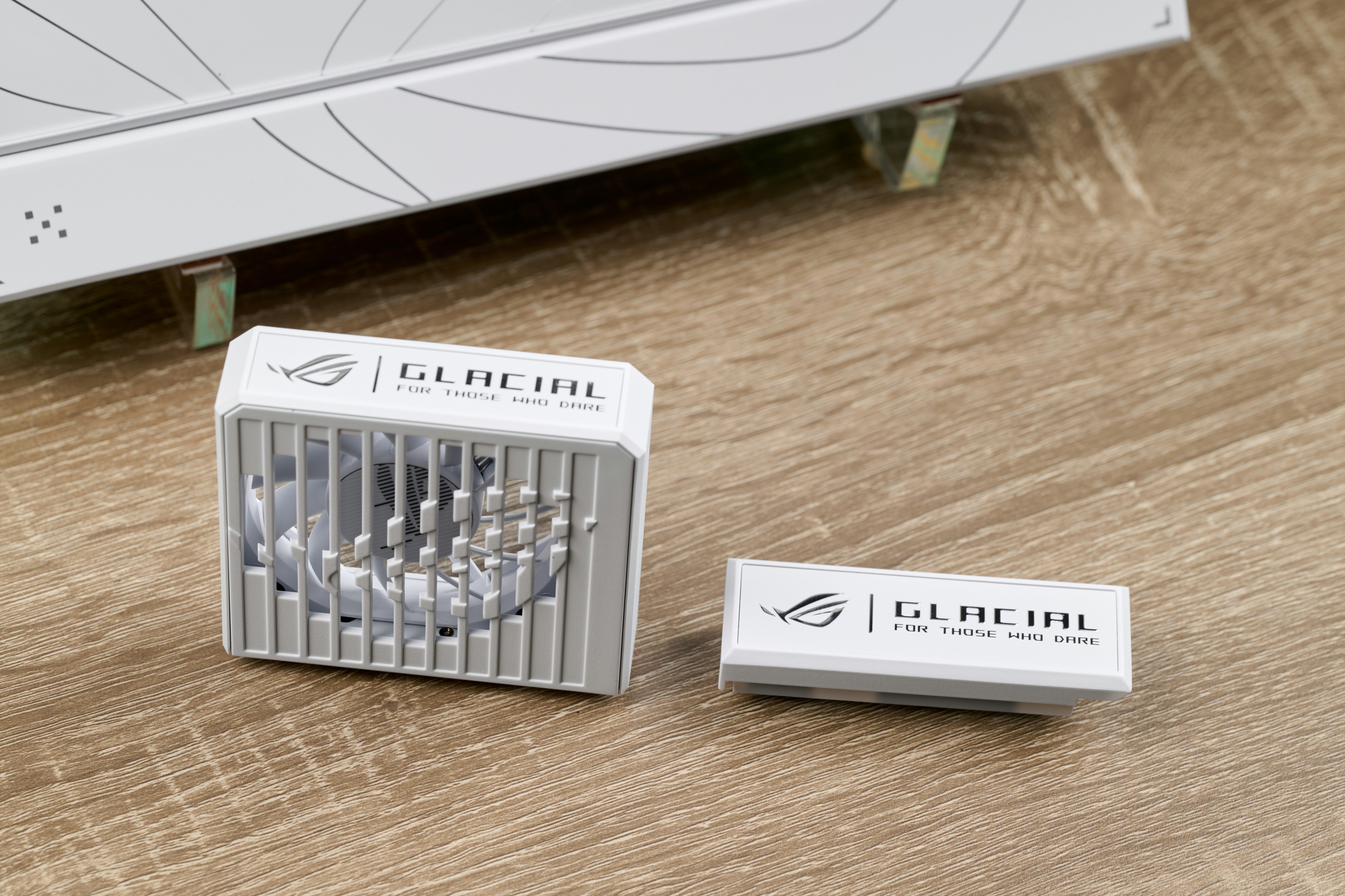 Two white computer fan components on a wooden surface.