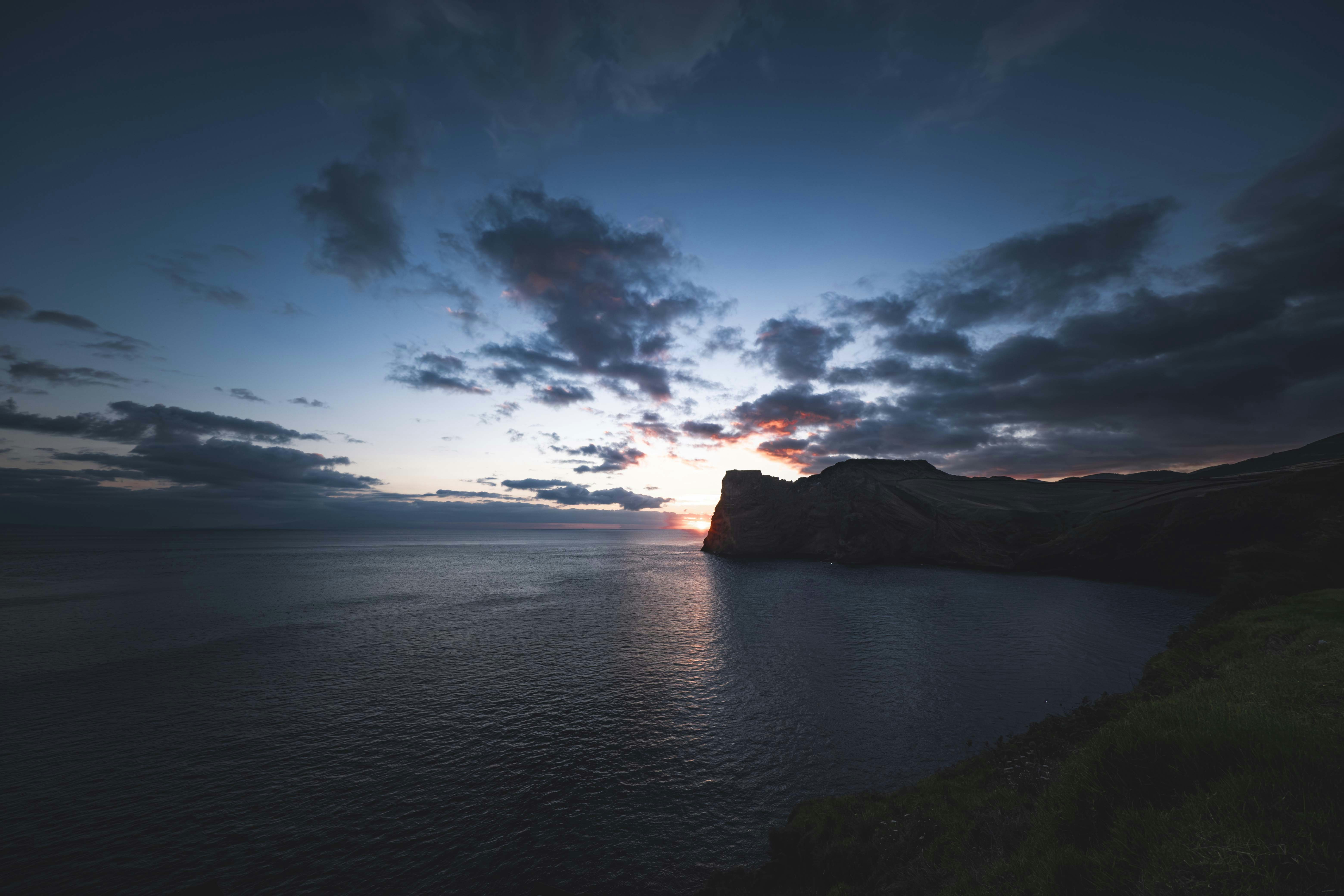 Sunset over a calm ocean with dramatic clouds