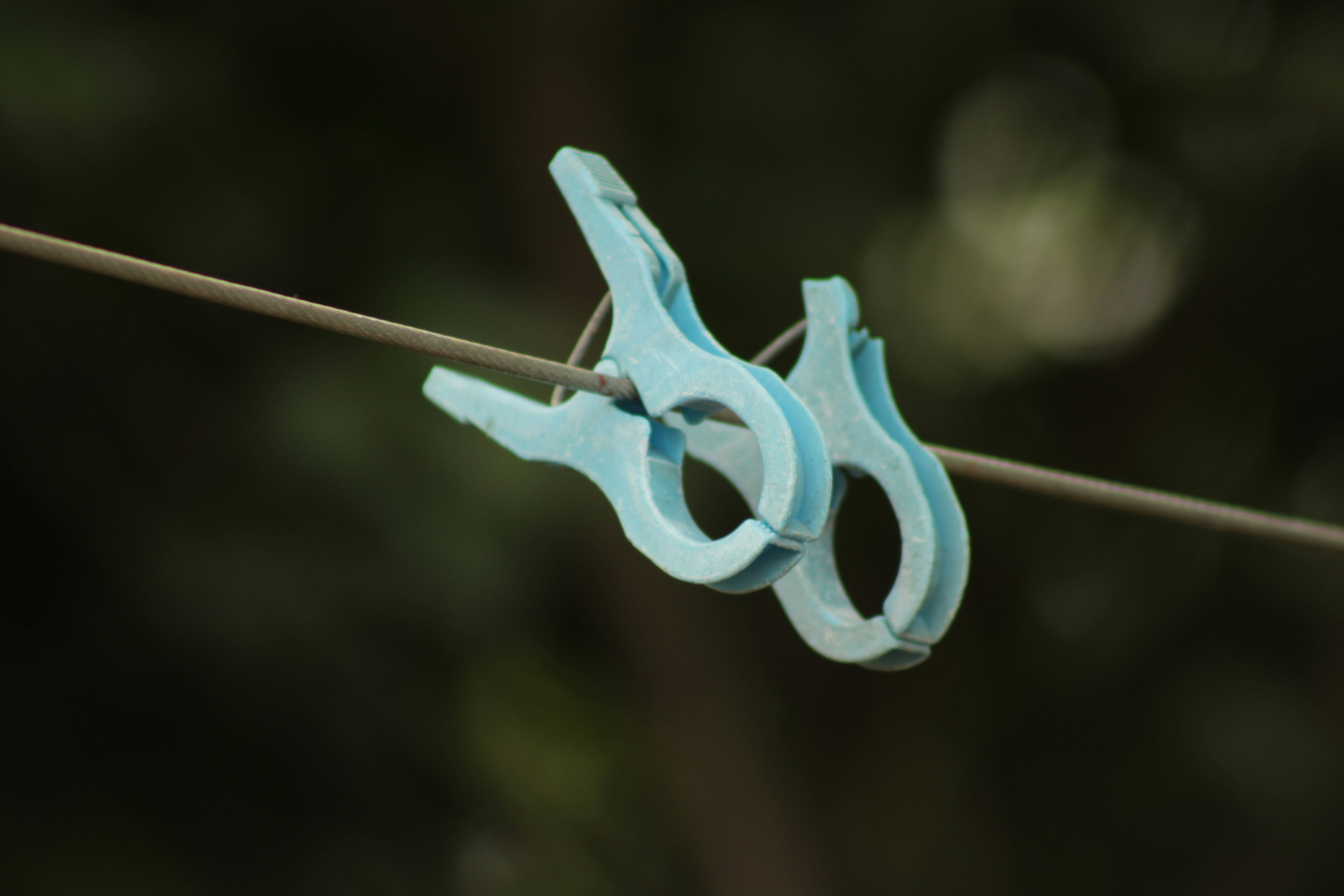Two light blue clothespins on a wire