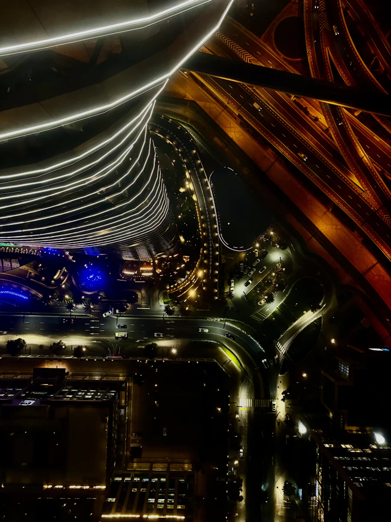 looking straight down a lit tower onto curving roads at night