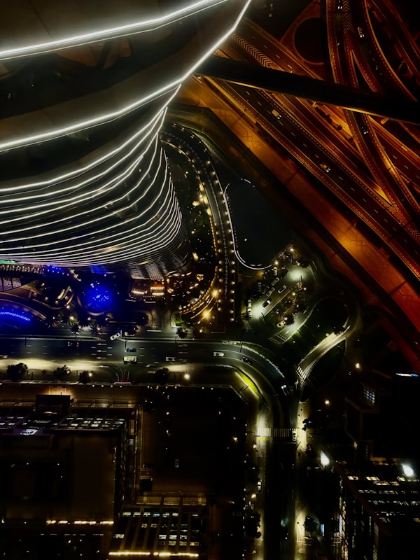 top-down view of night roads winding under light ribbons
