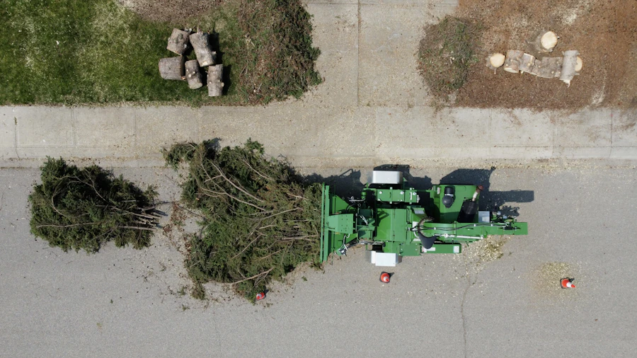 Overhead view of a wood chipper processing tree branches piled along a residential street