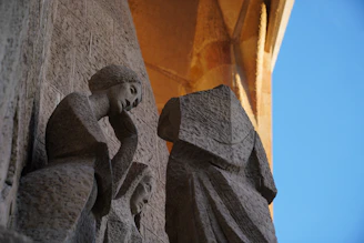 Stone sculptures on a building facade against blue sky