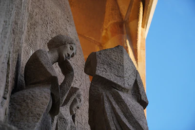Stone sculptures on a building facade against blue sky