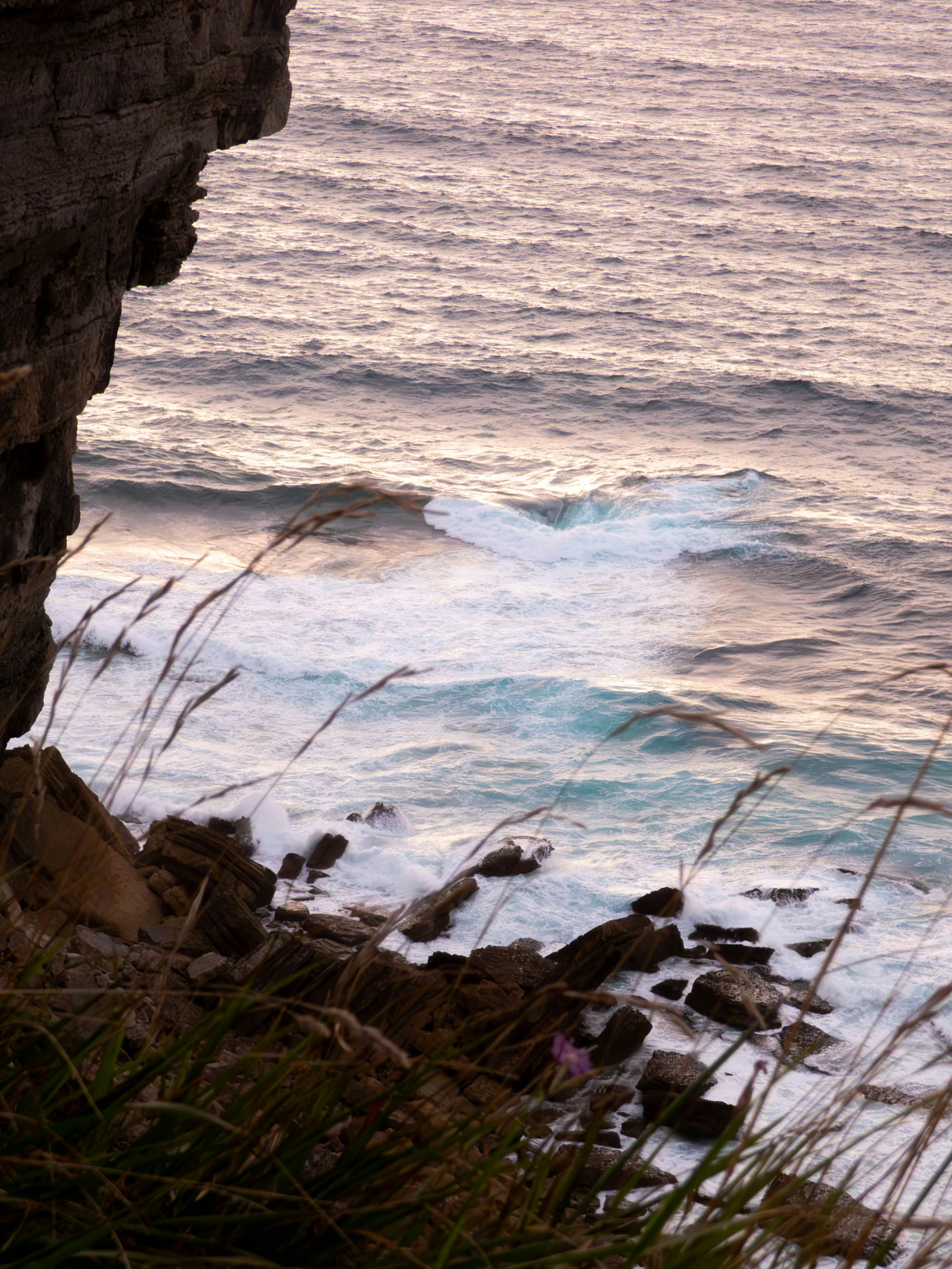 Waves crash on rocky shore near cliff
