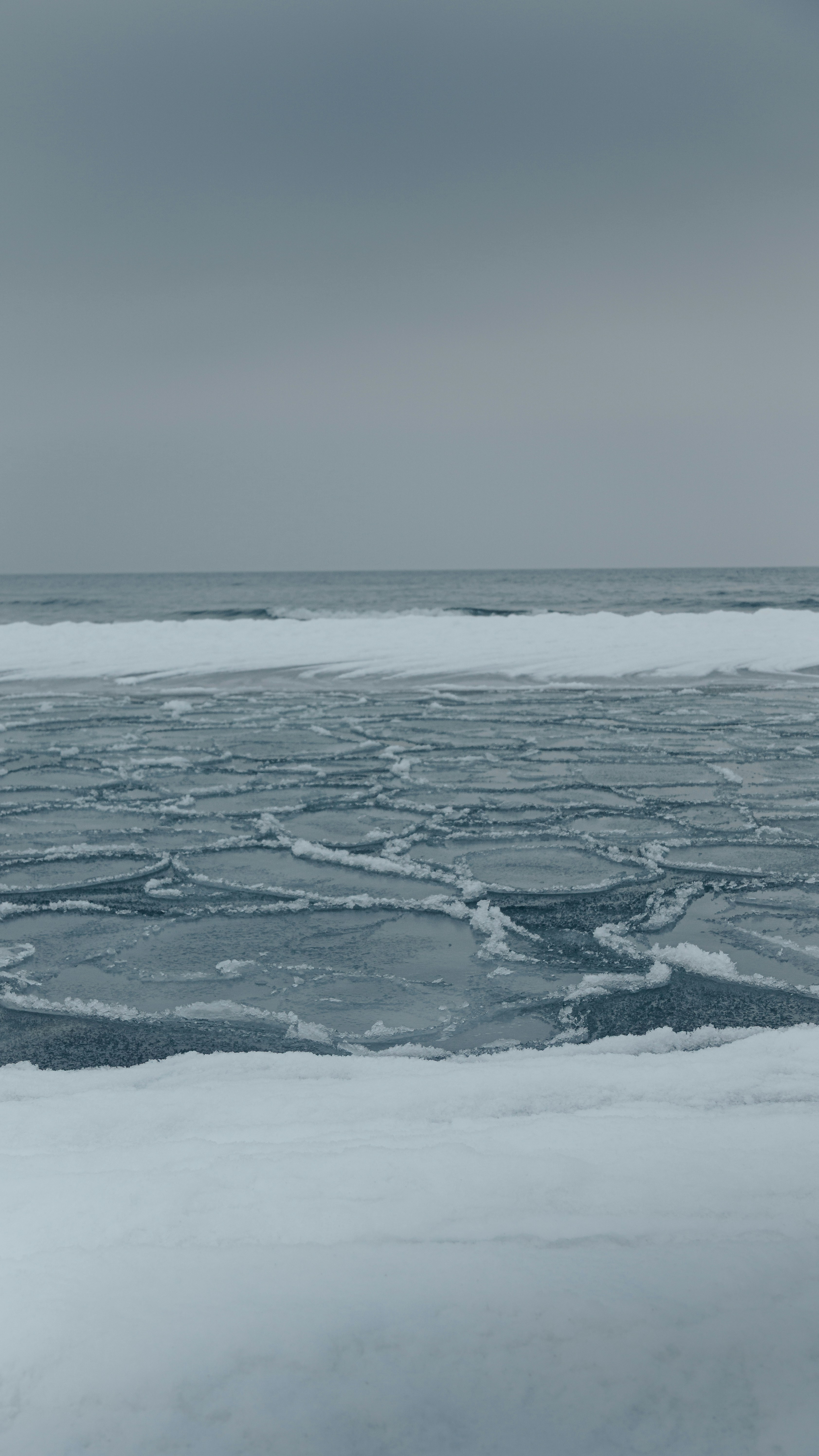 Ice floes on the ocean surface under a cloudy sky