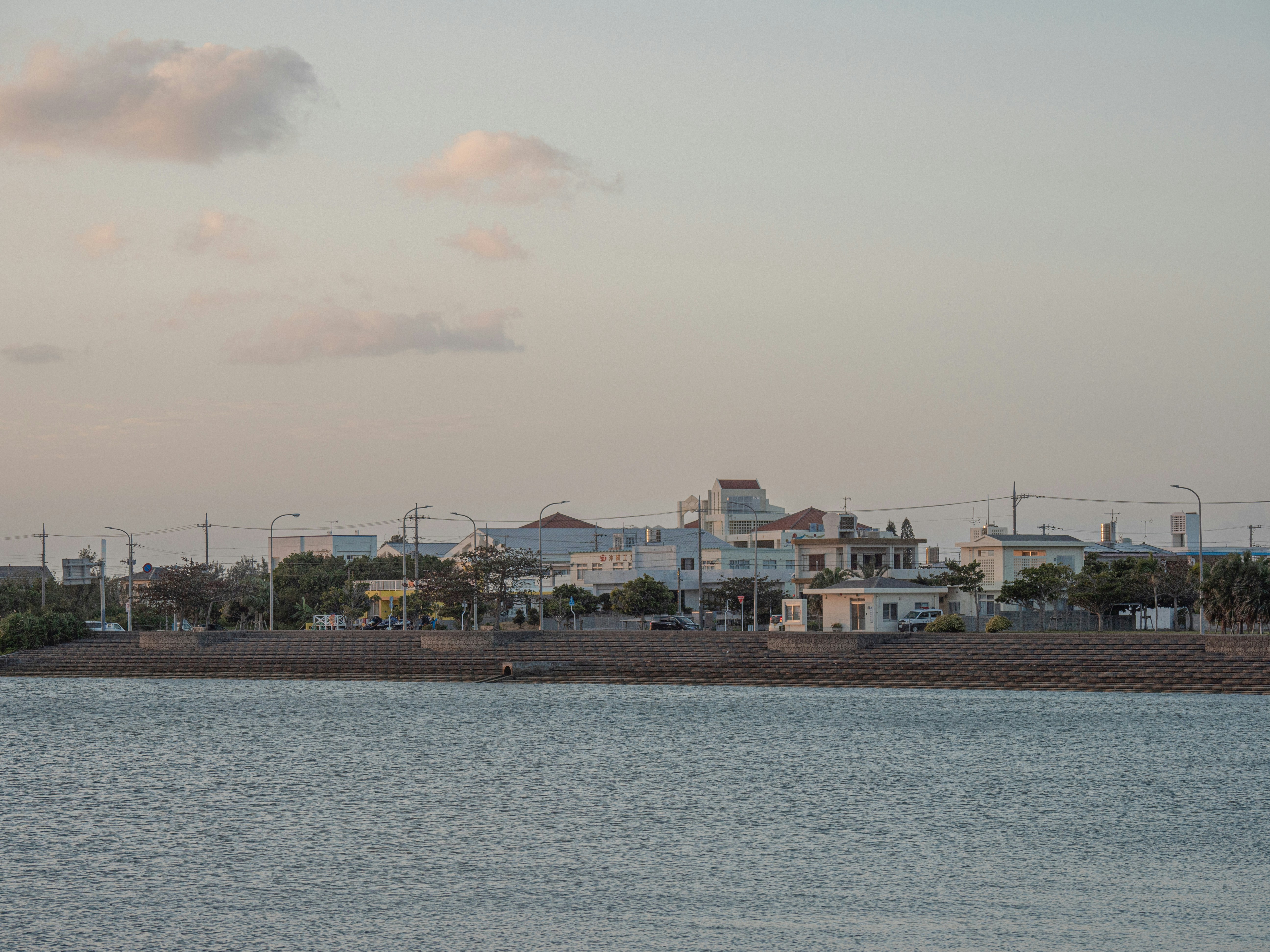 Buildings line the shore of a calm body of water.