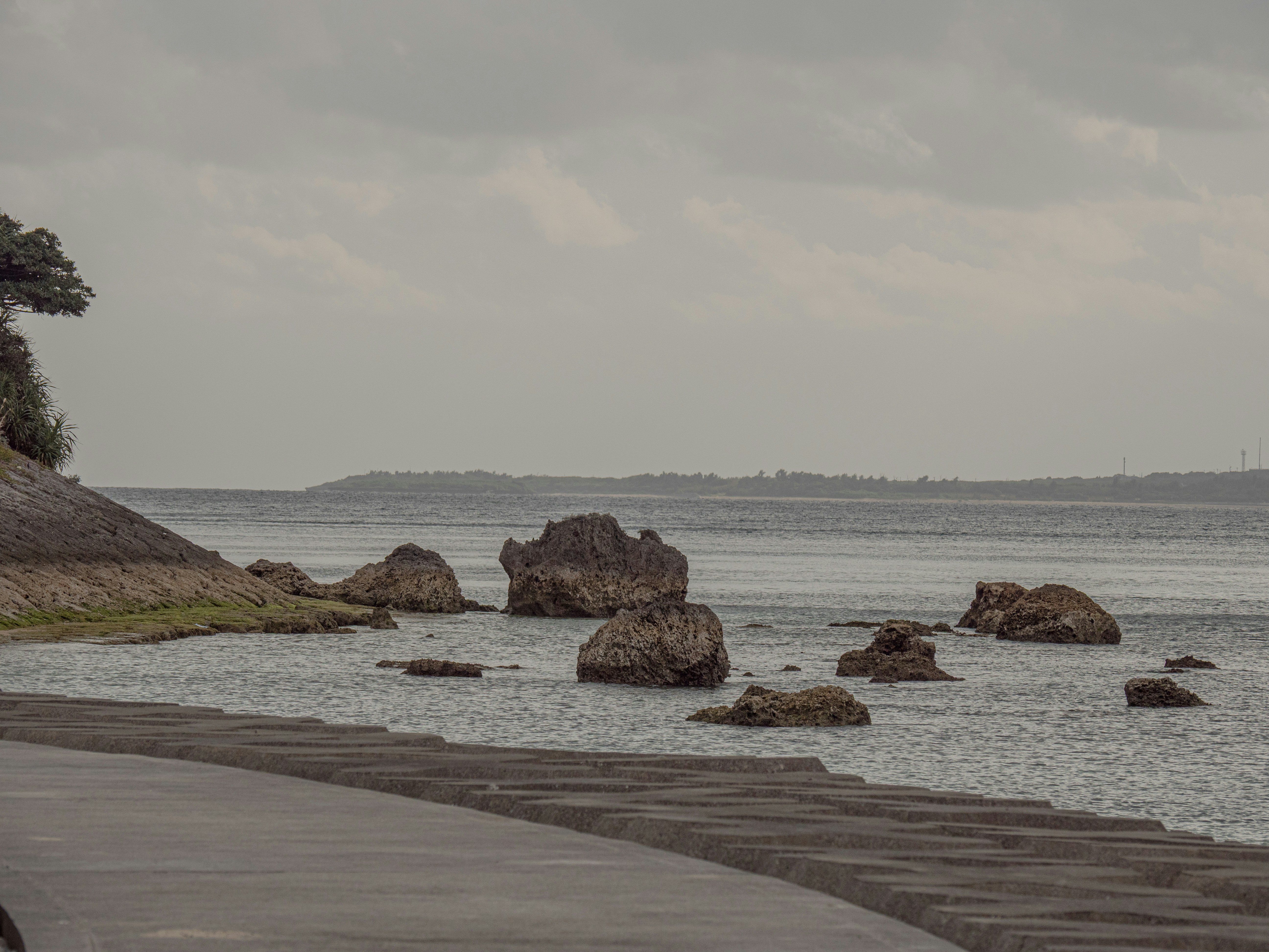 Rocky shore with calm water under an overcast sky