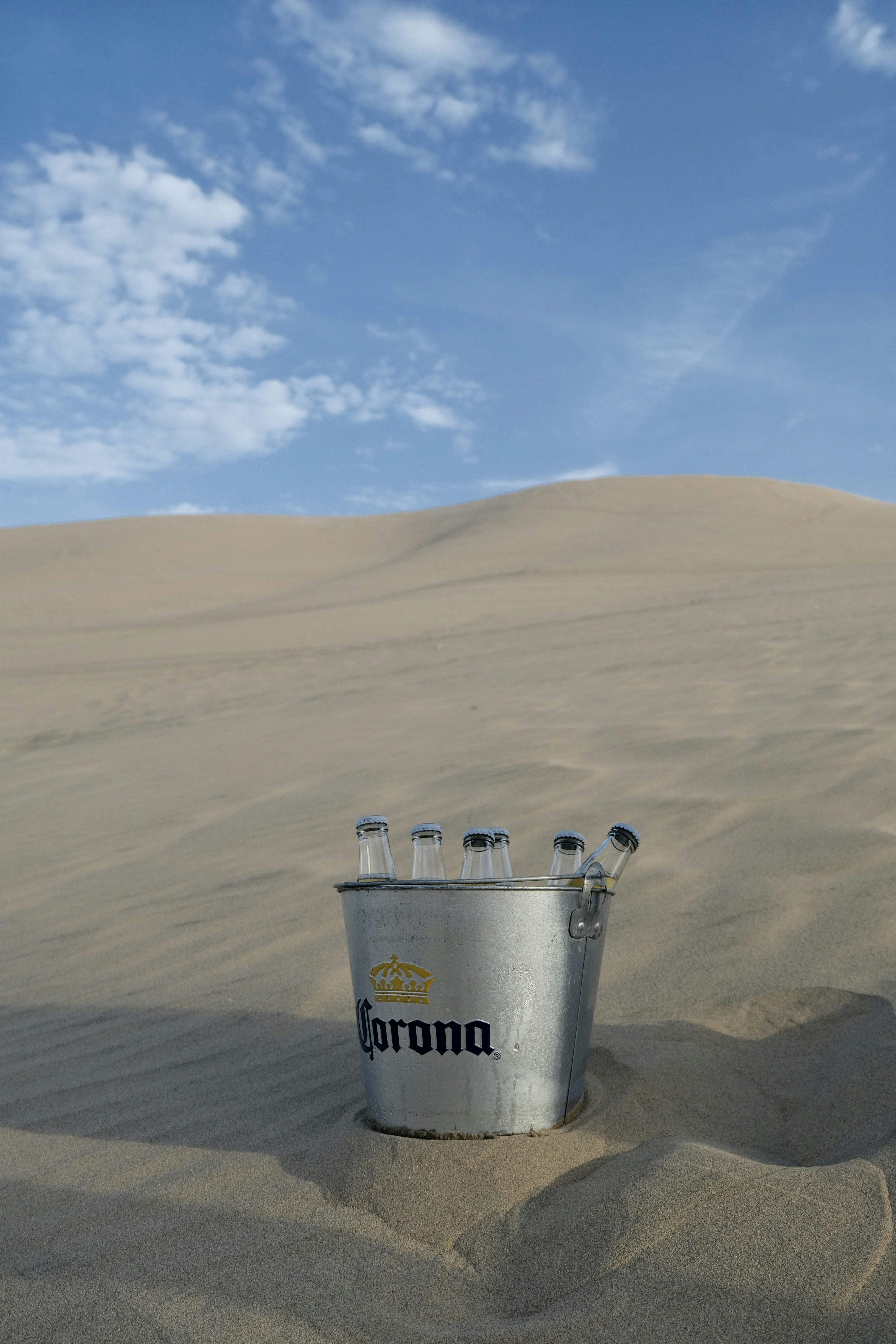 Corona bucket with bottles in sand dunes