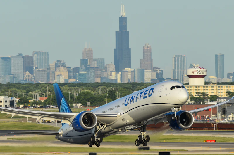 A United Airlines jet taking off from O'Hare International Airport with the Chicago skyline behind it
