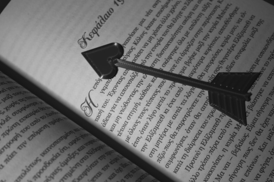 Heart-shaped arrow bookmark in an open book