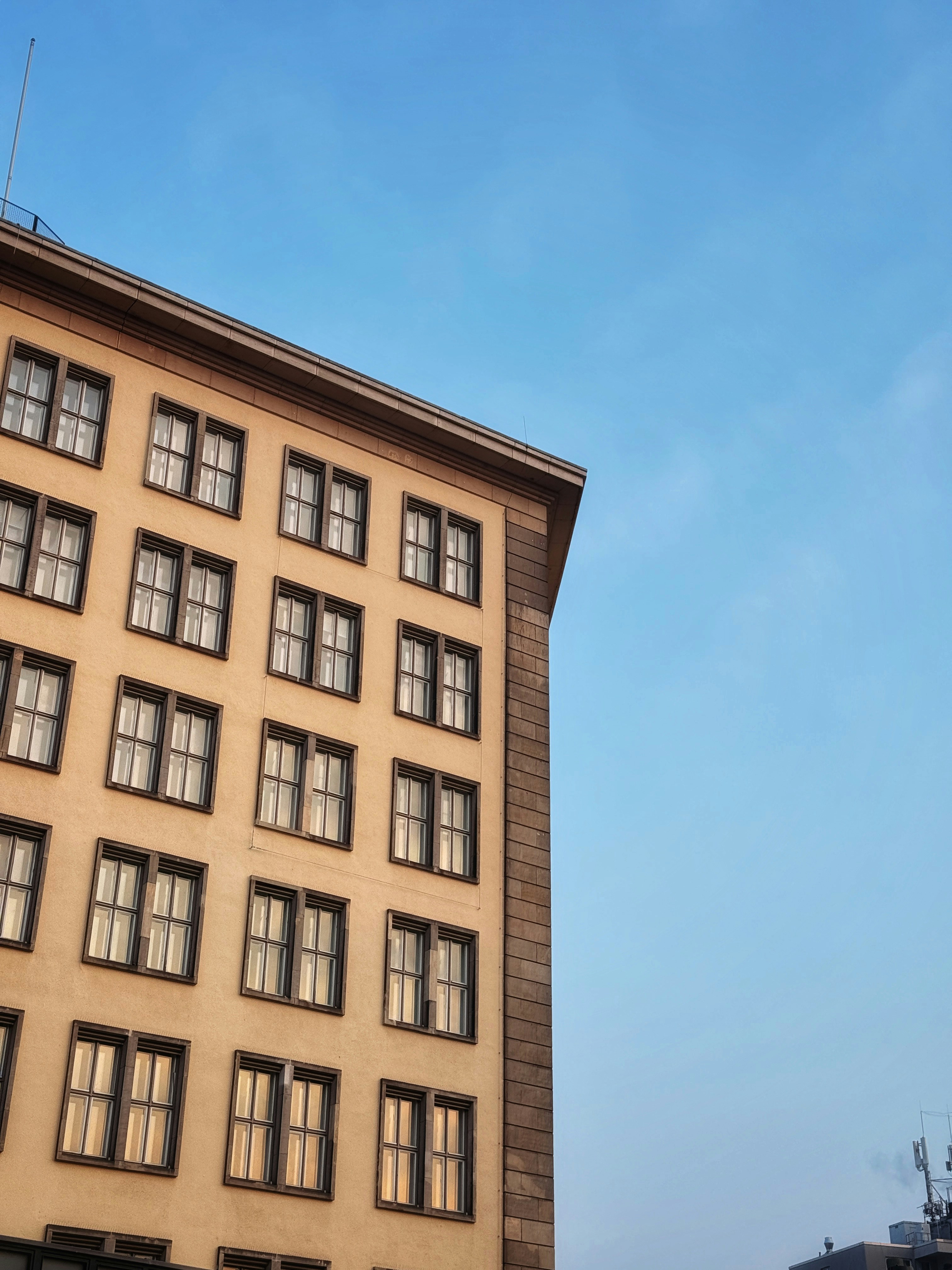 Apartment building facade against a clear blue sky.