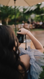 Woman with camera taking a picture of a bride.