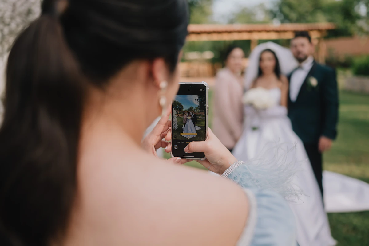 A wedding guest taking a photo on their phone