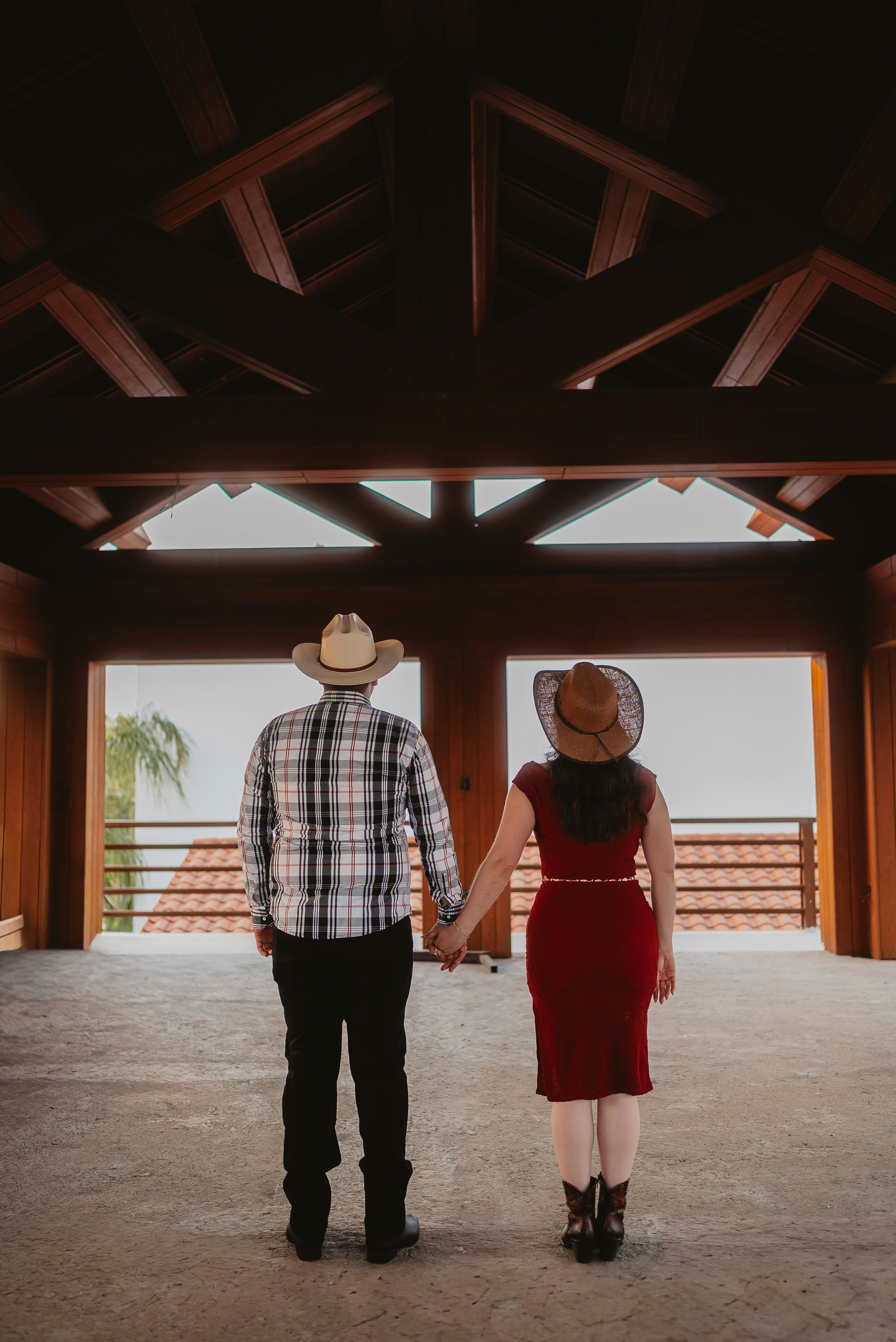 Couple in cowboy hats holding hands indoors