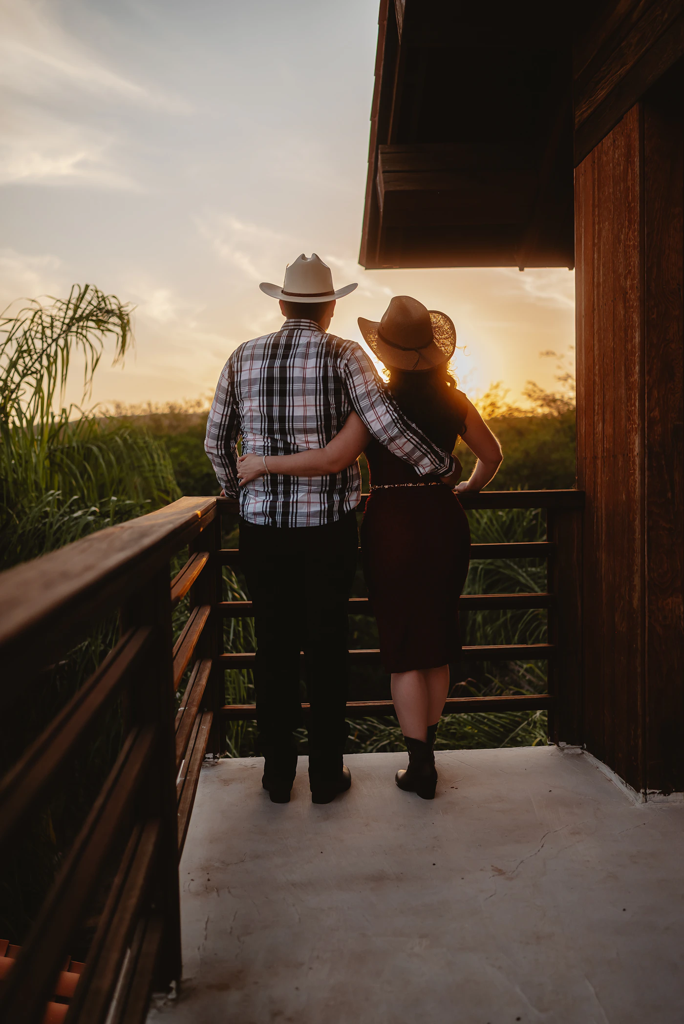 Couple in elopement attire walking between the vine rows at a Prince Edward County winery with the grapevines and the pastoral Ontario countryside giving the setting