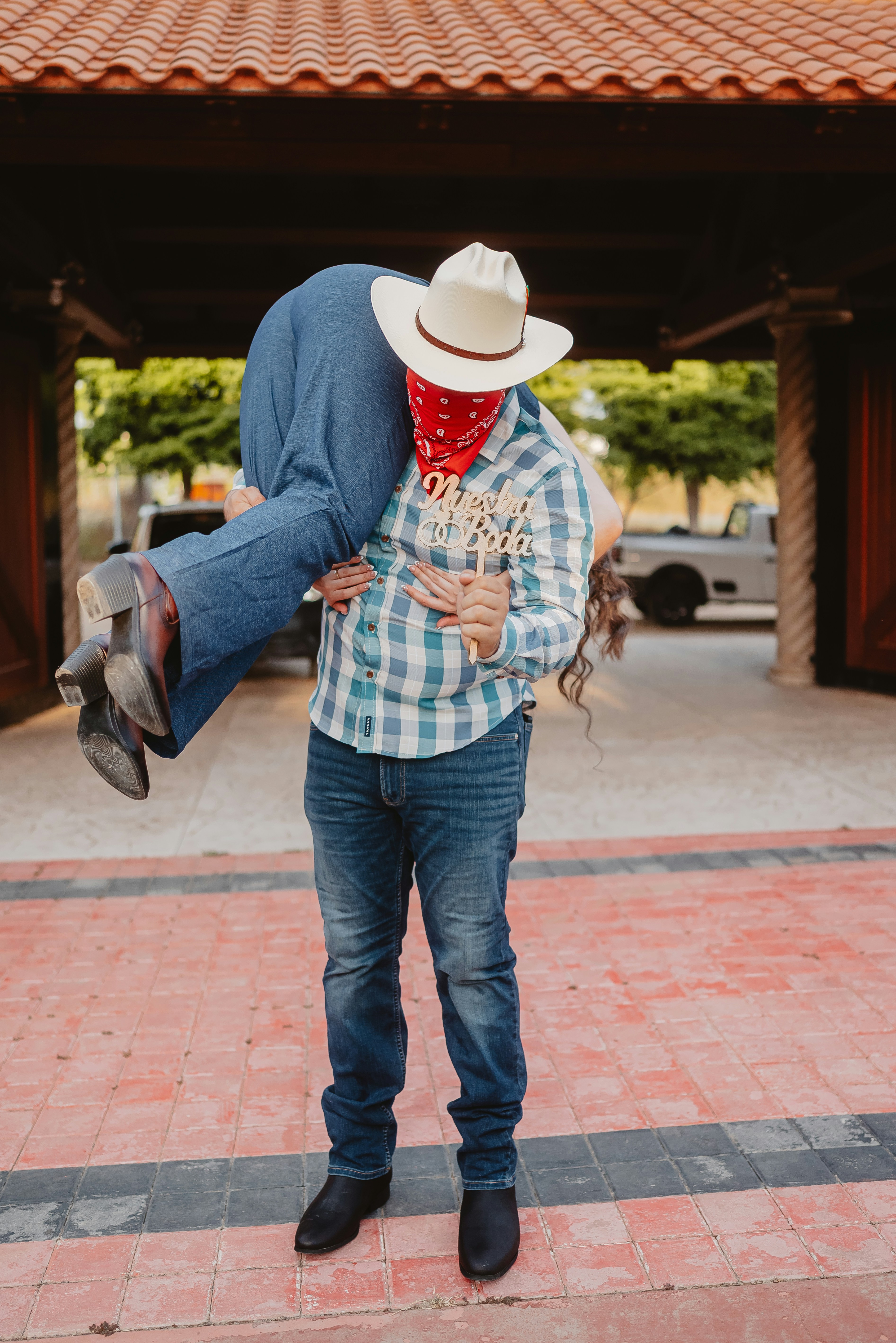 Cowboy carrying woman with cowboy hat and bandana
