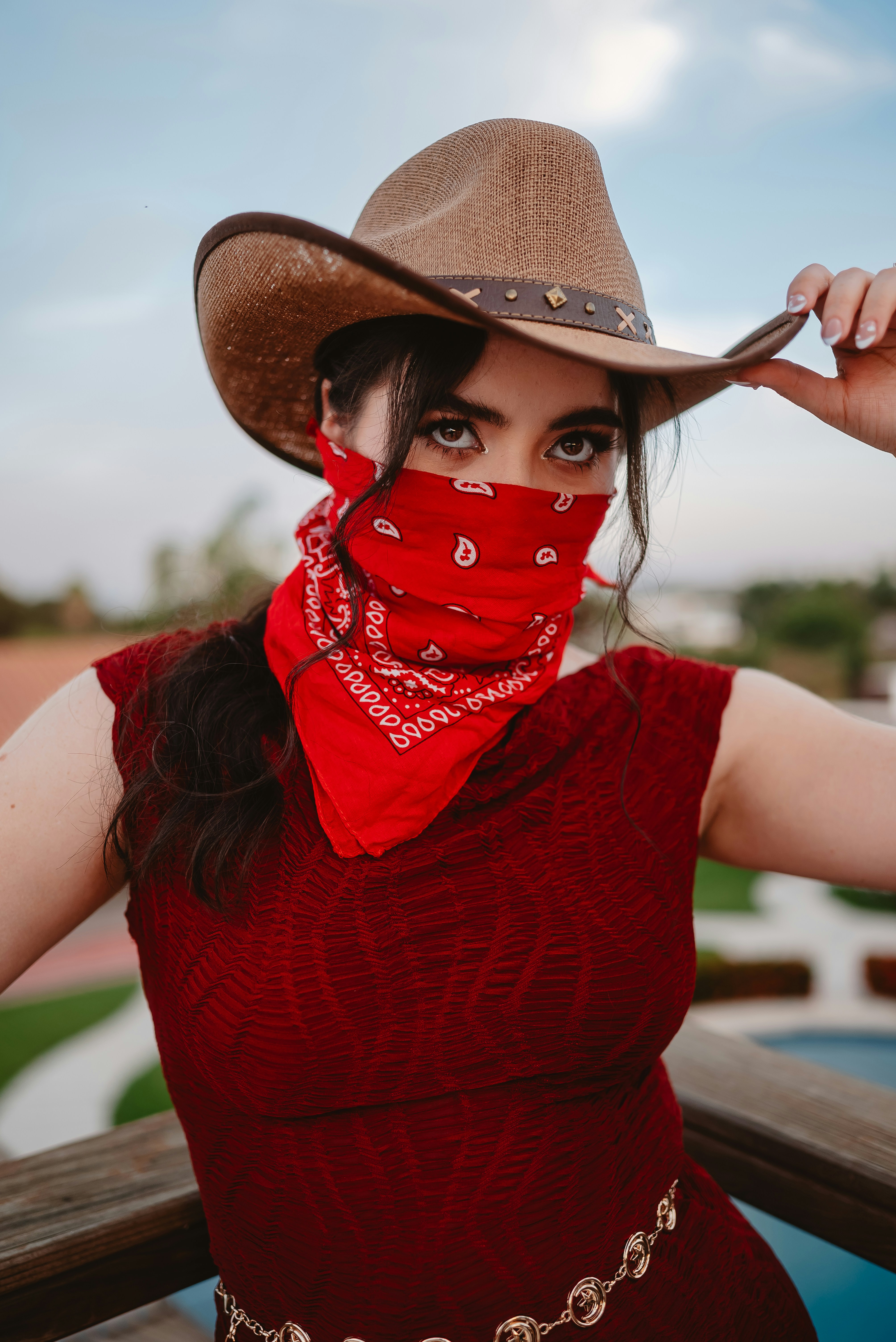 Cowgirl in hat and bandana covers face