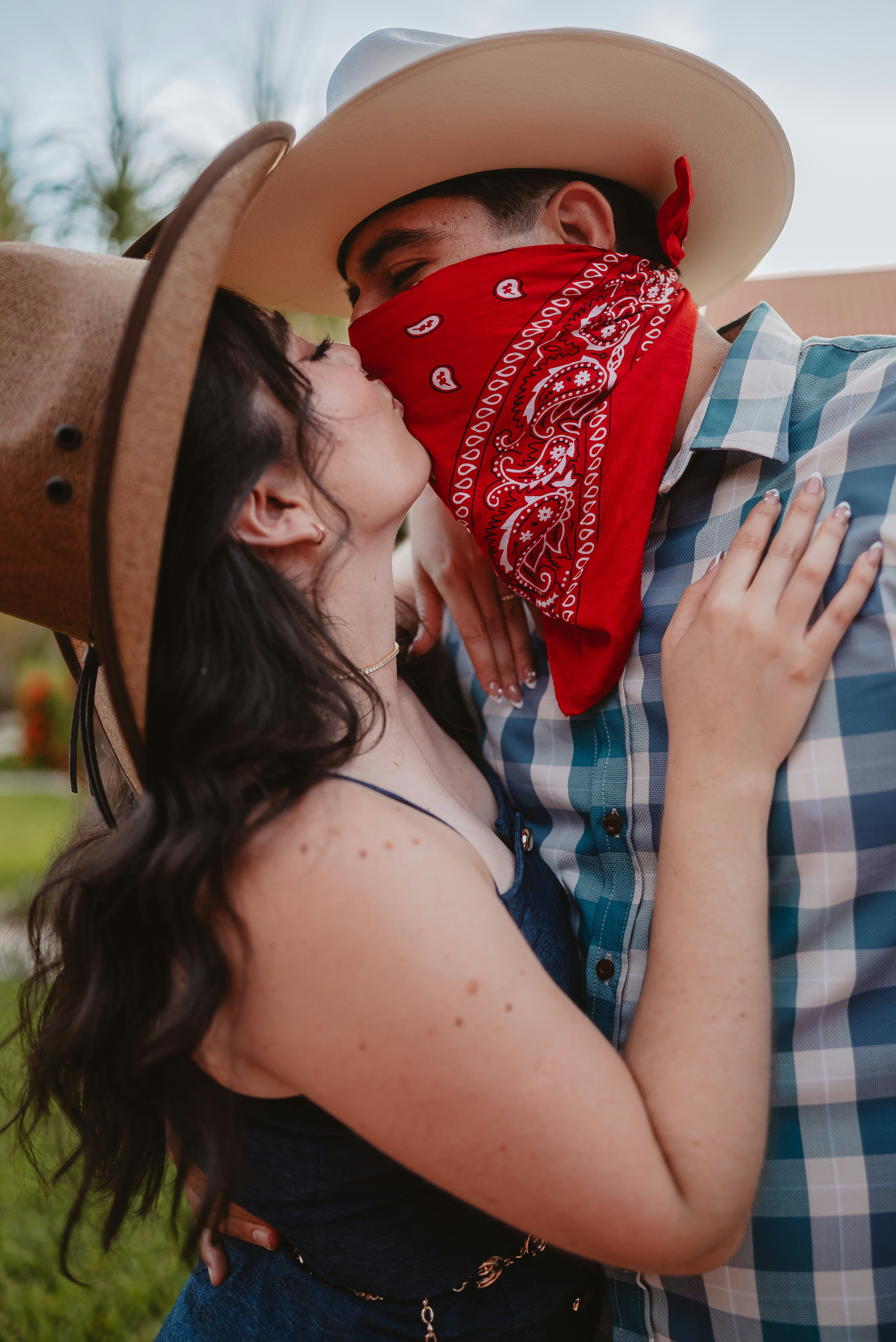 Couple in cowboy hats kissing with red bandanas