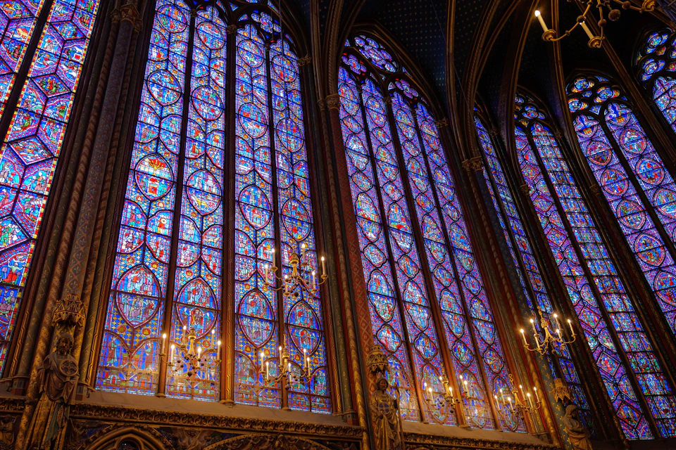 Gothic-style church interior features tall arches and stained glass windows filling the space completely
