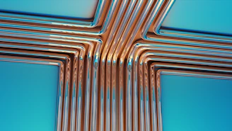 Copper pipes forming a cross shape on blue background