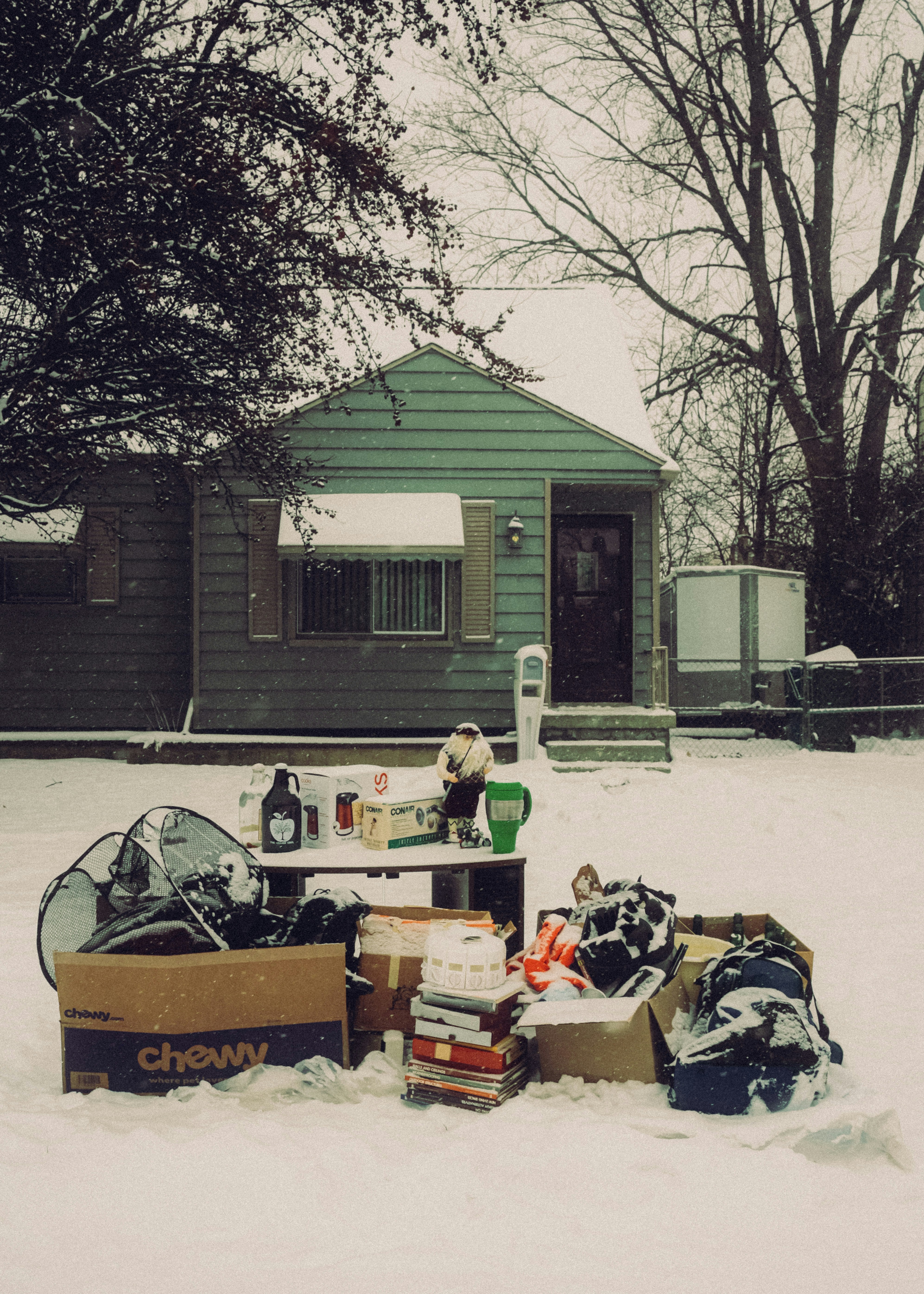 boxes and household items outside a small house