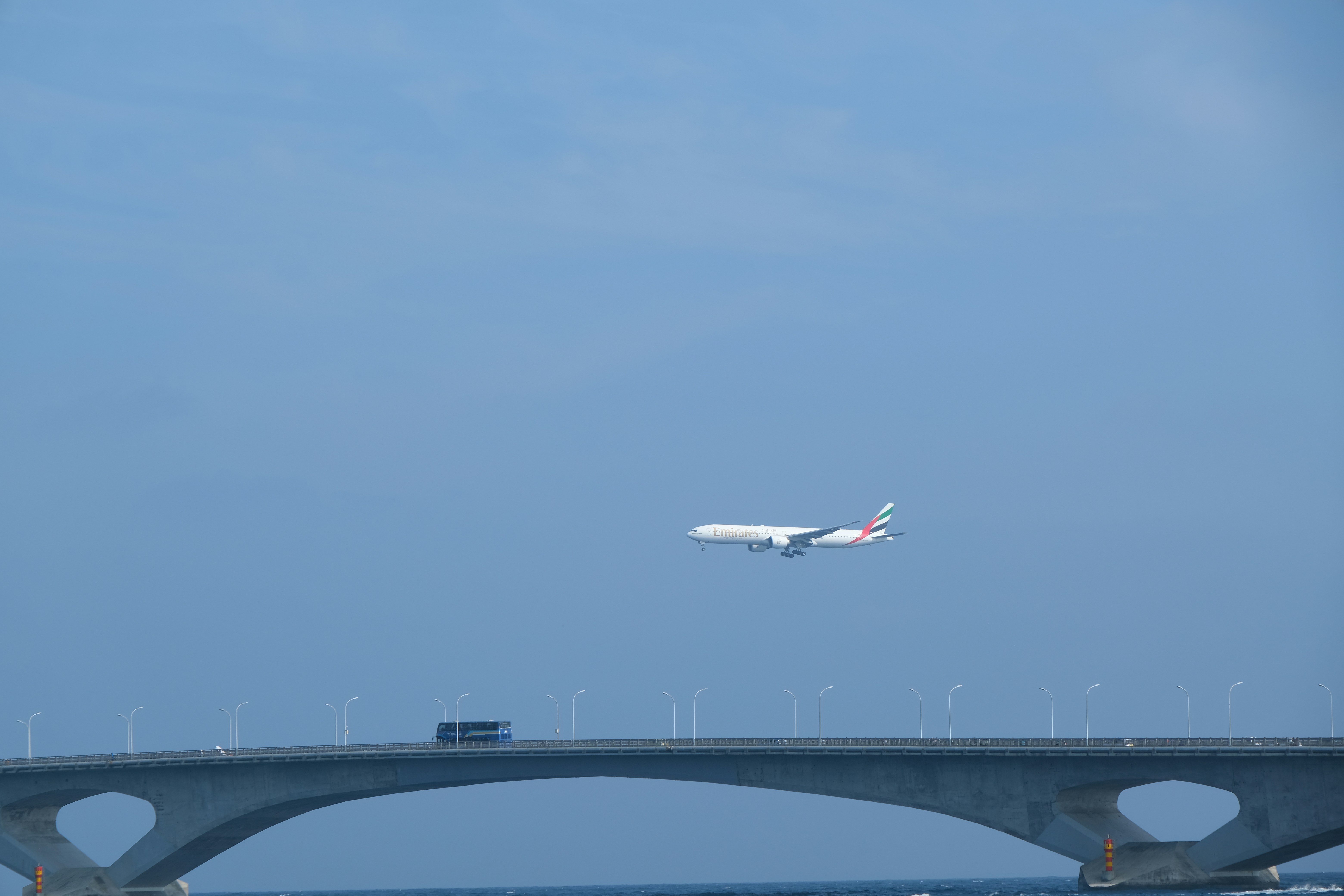 Das Flugzeug fliegt über eine Brücke und einen Ozean.
