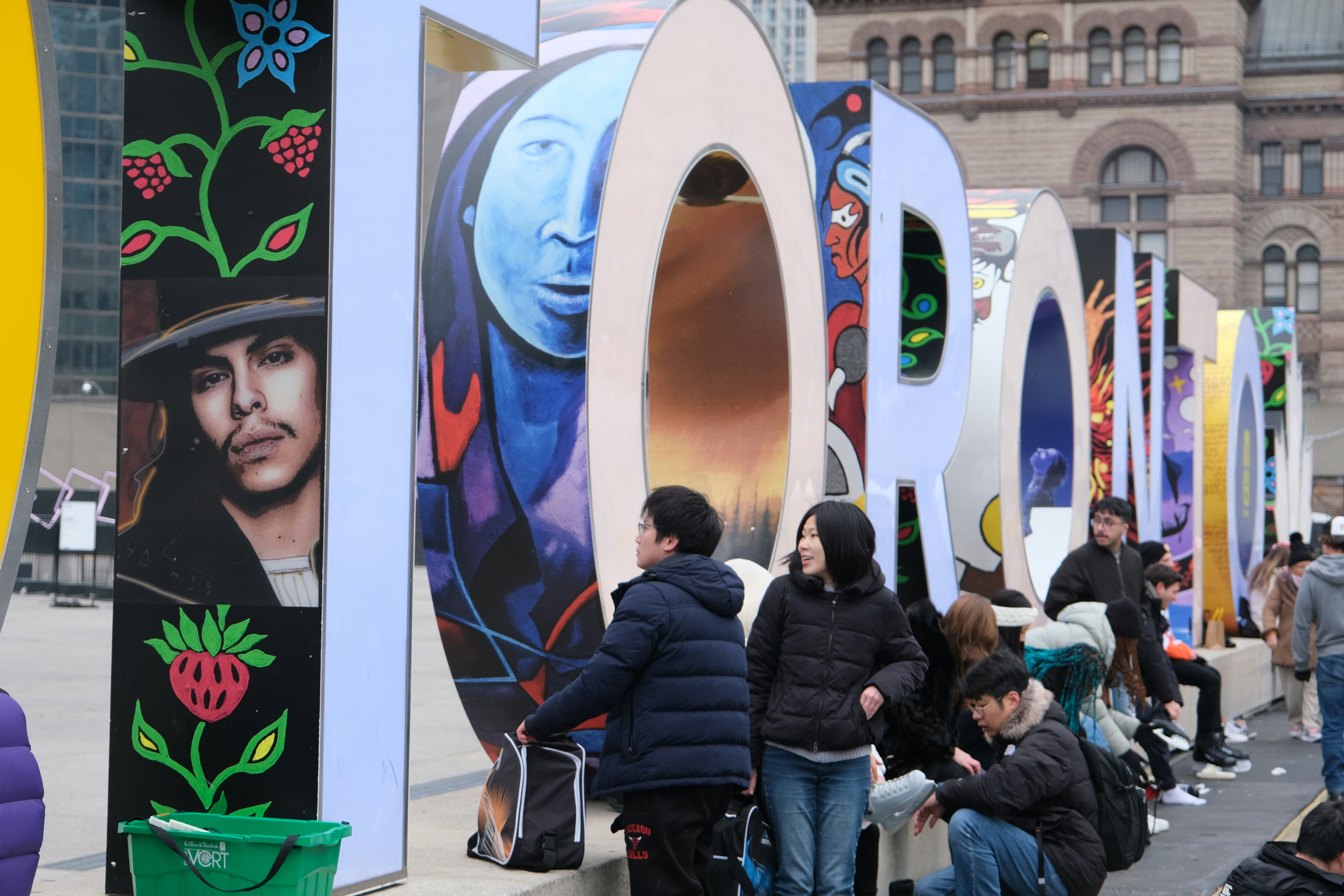 Große bunte Kunstinstallation mit posierenden Menschen