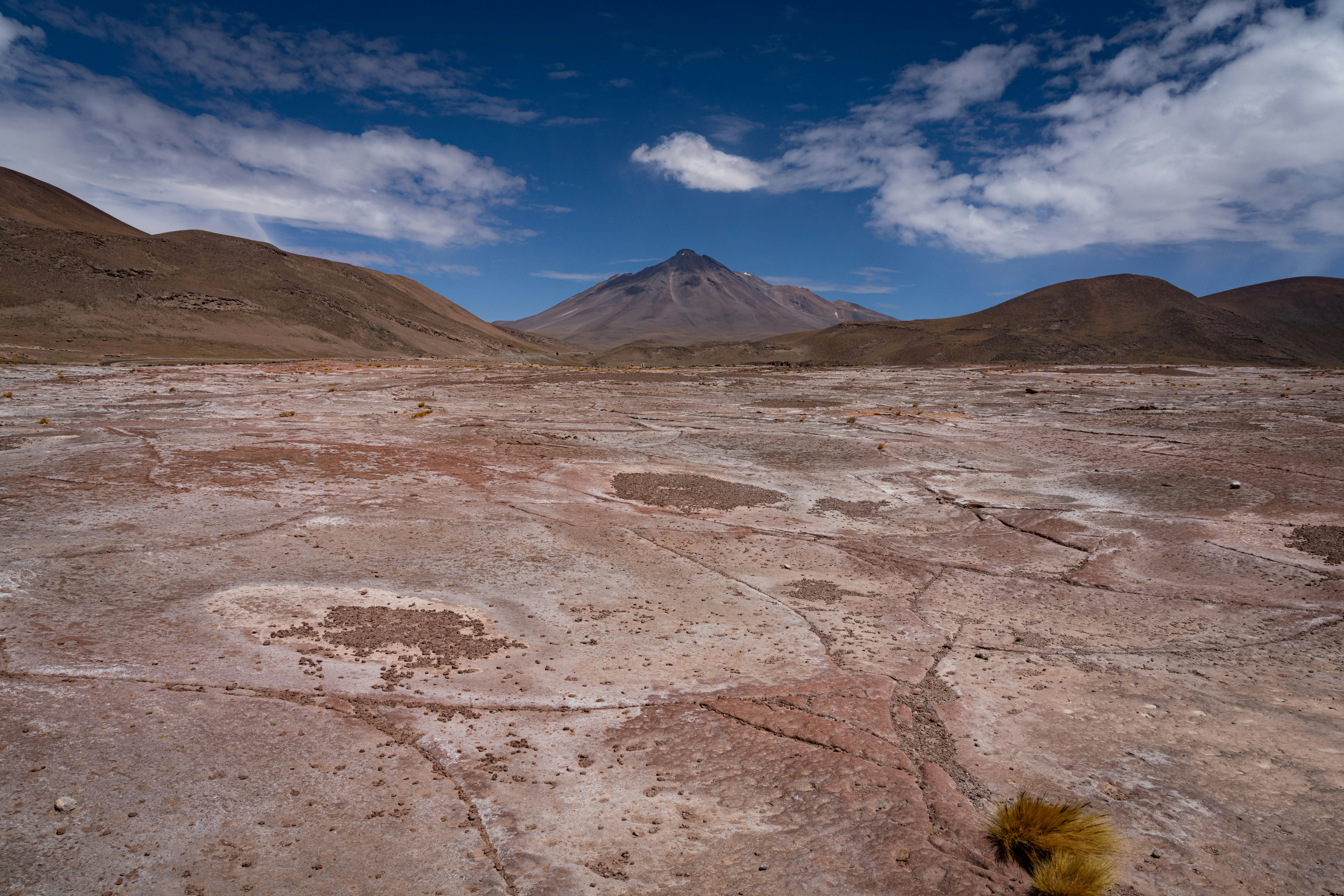 Arid landscape with mountains and a distant volcano.