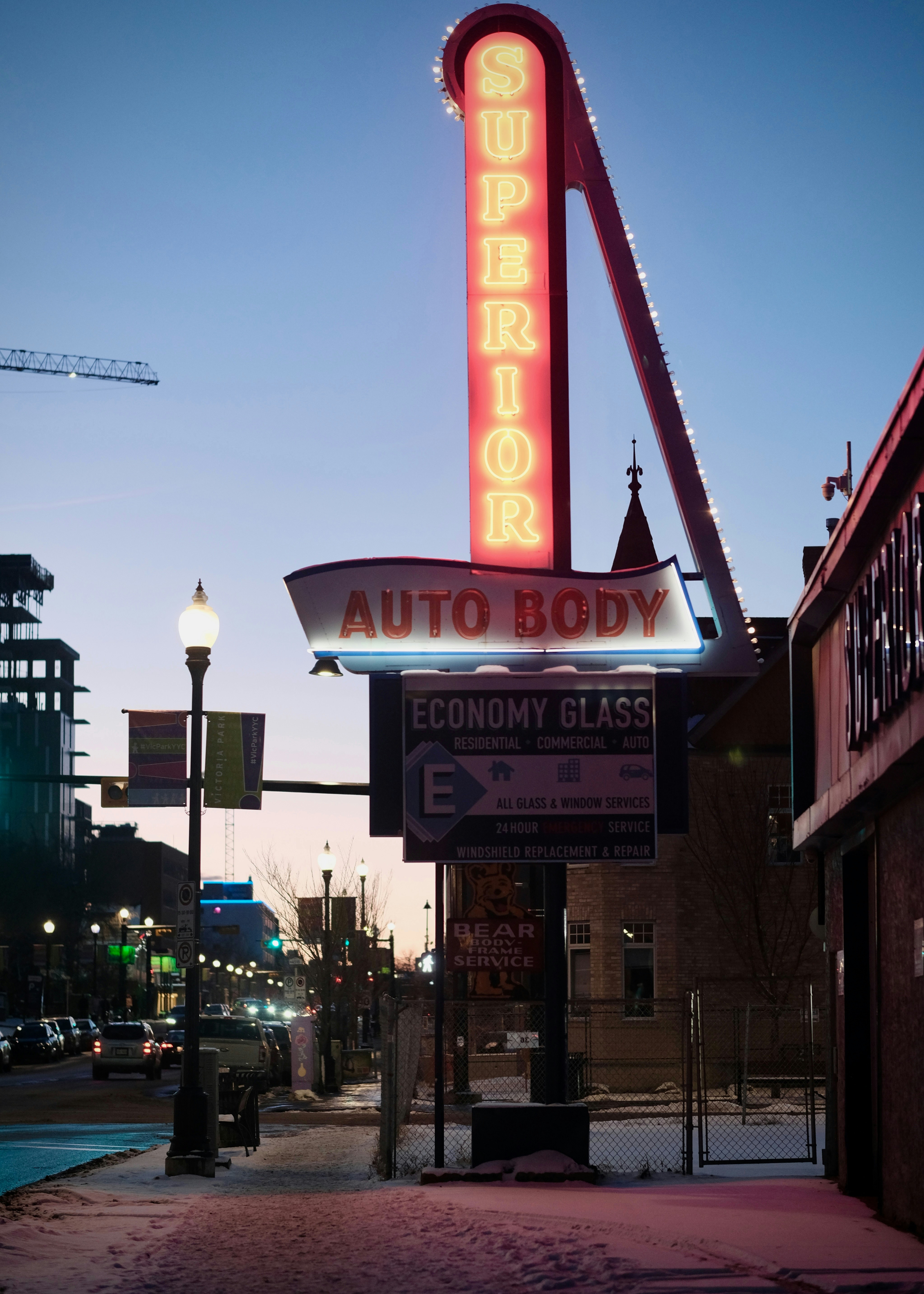 Retro neon sign for superior auto body at dusk