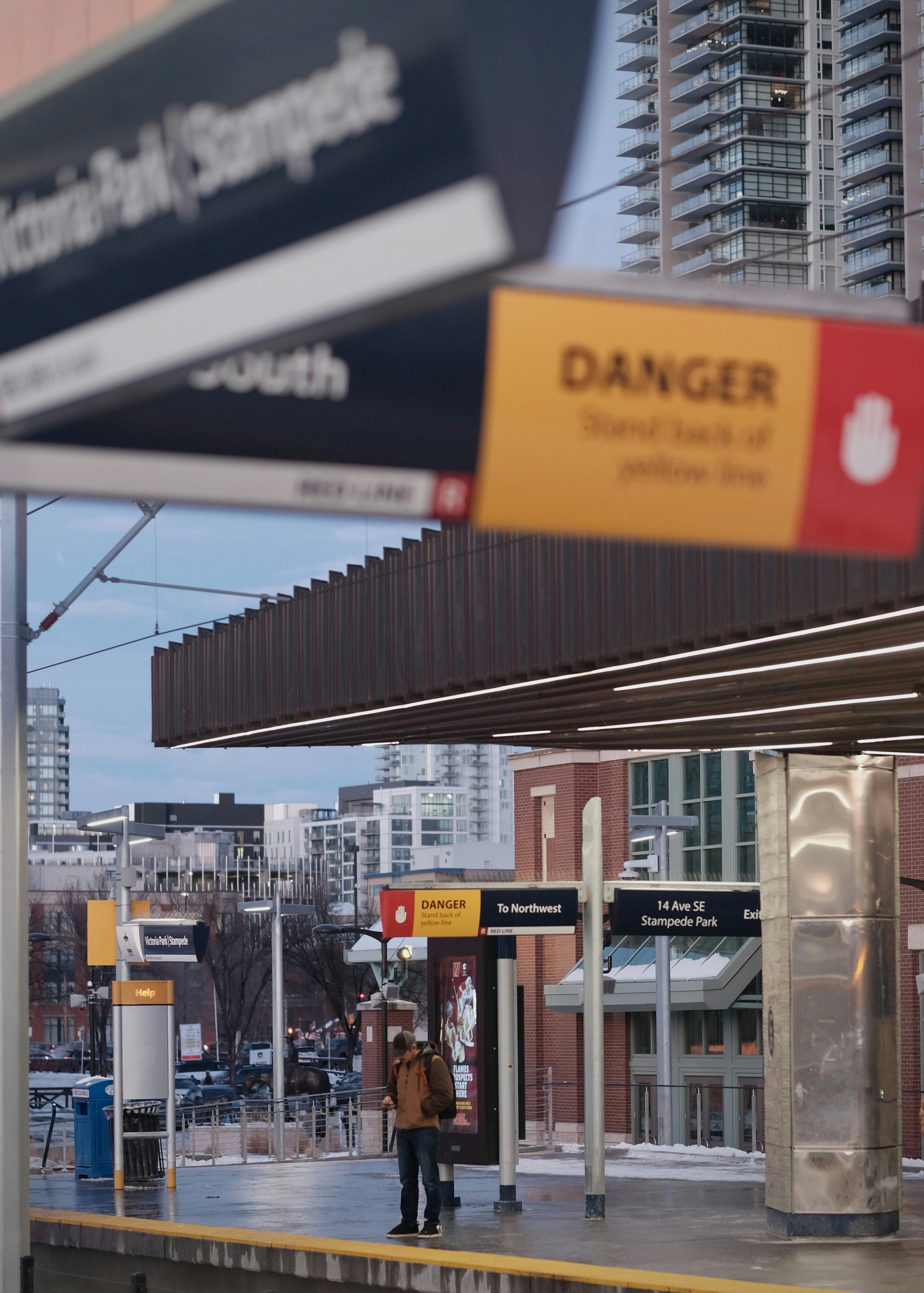 Man standing on train platform with buildings behind