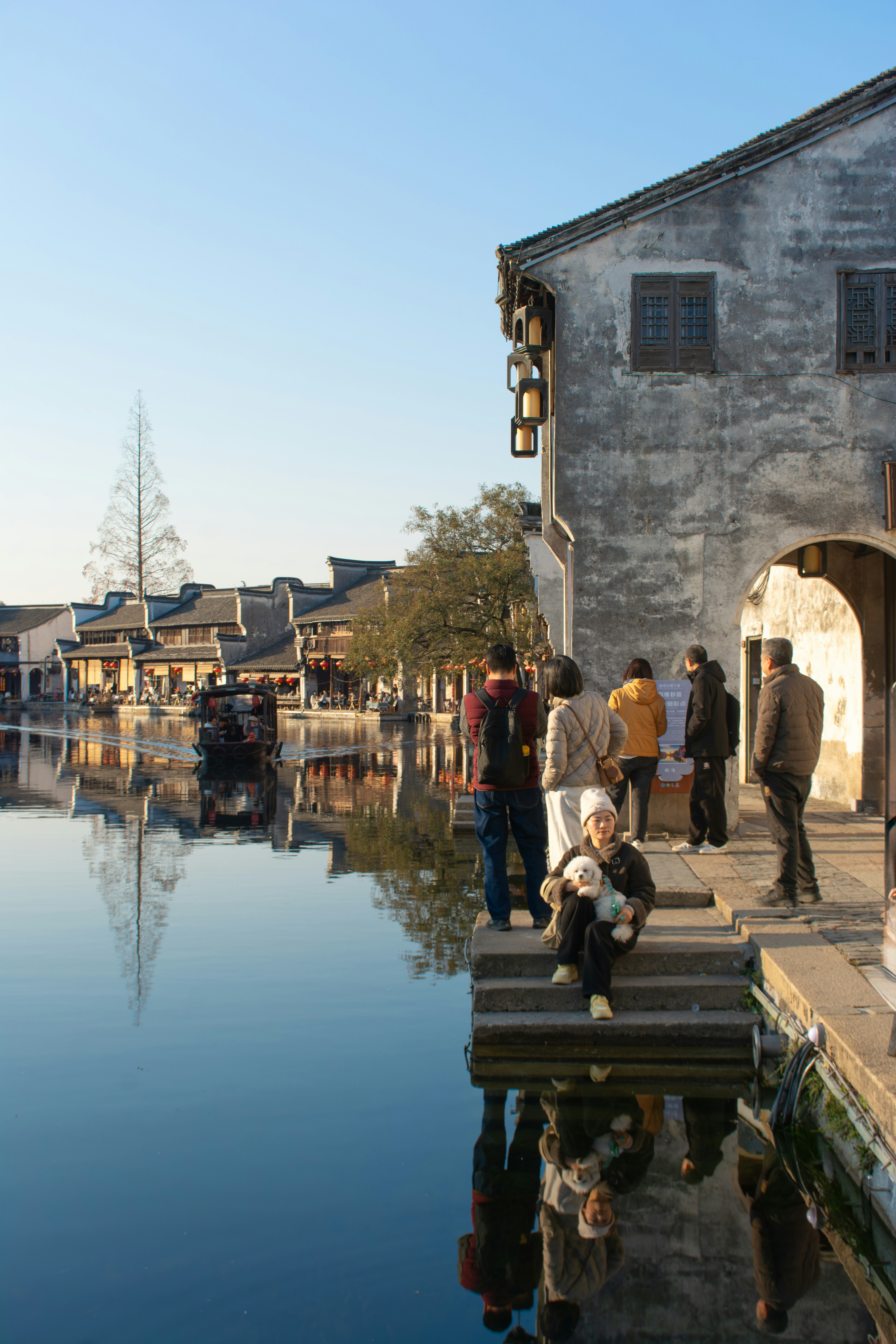 Die Menschen versammeln sich an einem ruhigen Kanal in einer alten Stadt.
