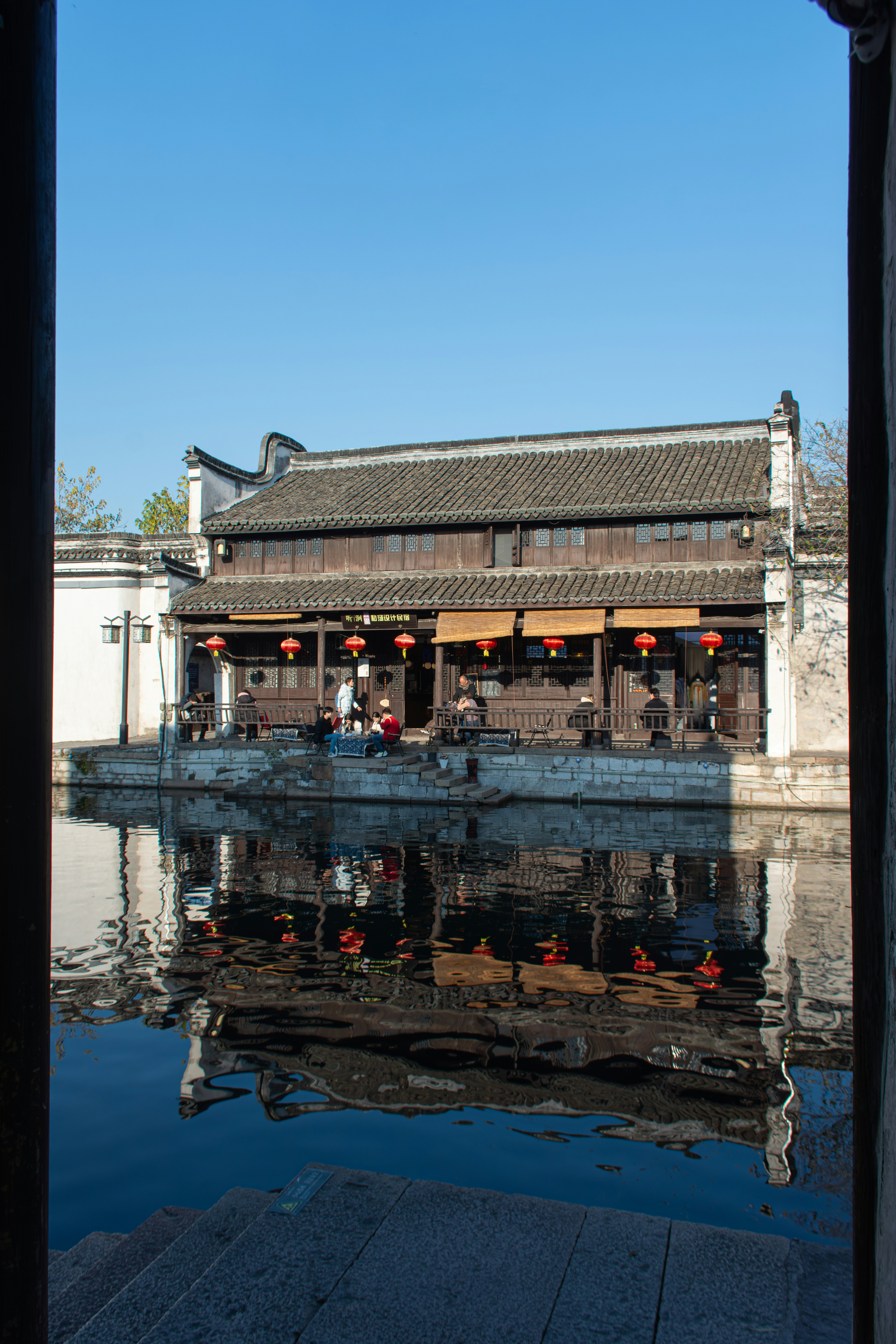 Traditionelle chinesische Gebäude spiegeln sich in einem ruhigen Kanal wider
