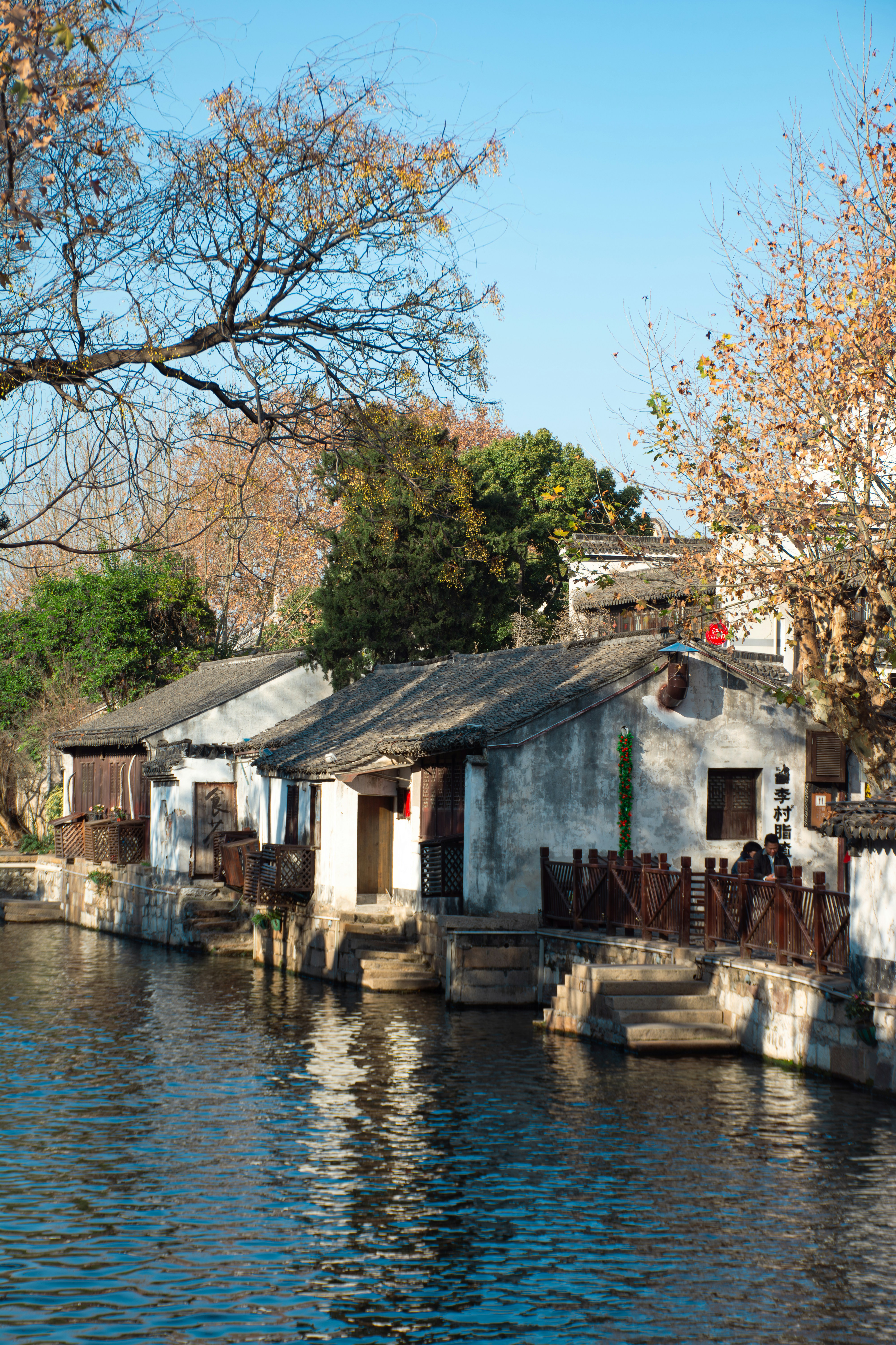Alte Gebäude säumen einen ruhigen Kanal unter klarem Himmel.