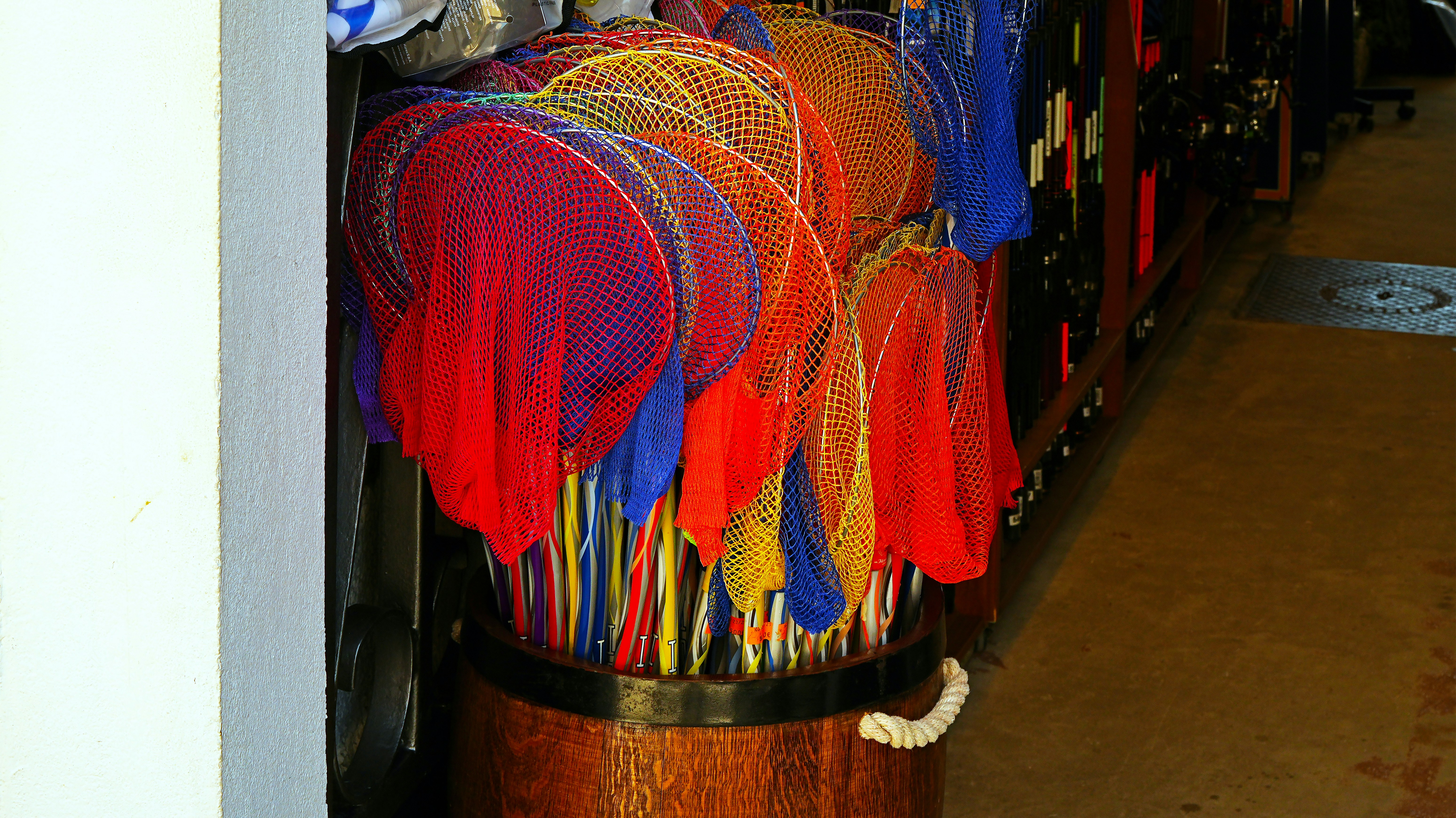 Bunte Fächer in einem Holzfass präsentiert.