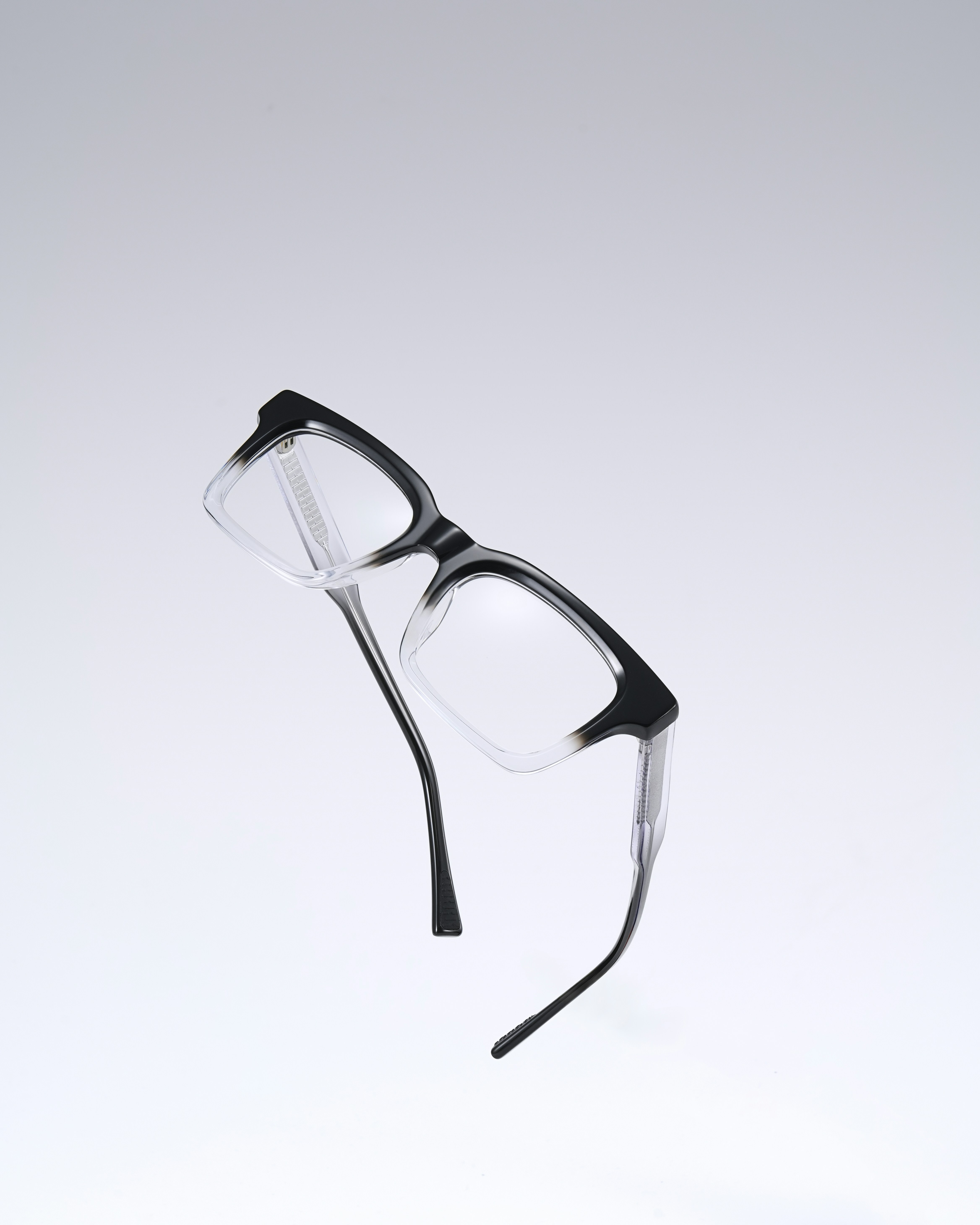 A pair of black and clear eyeglasses floating