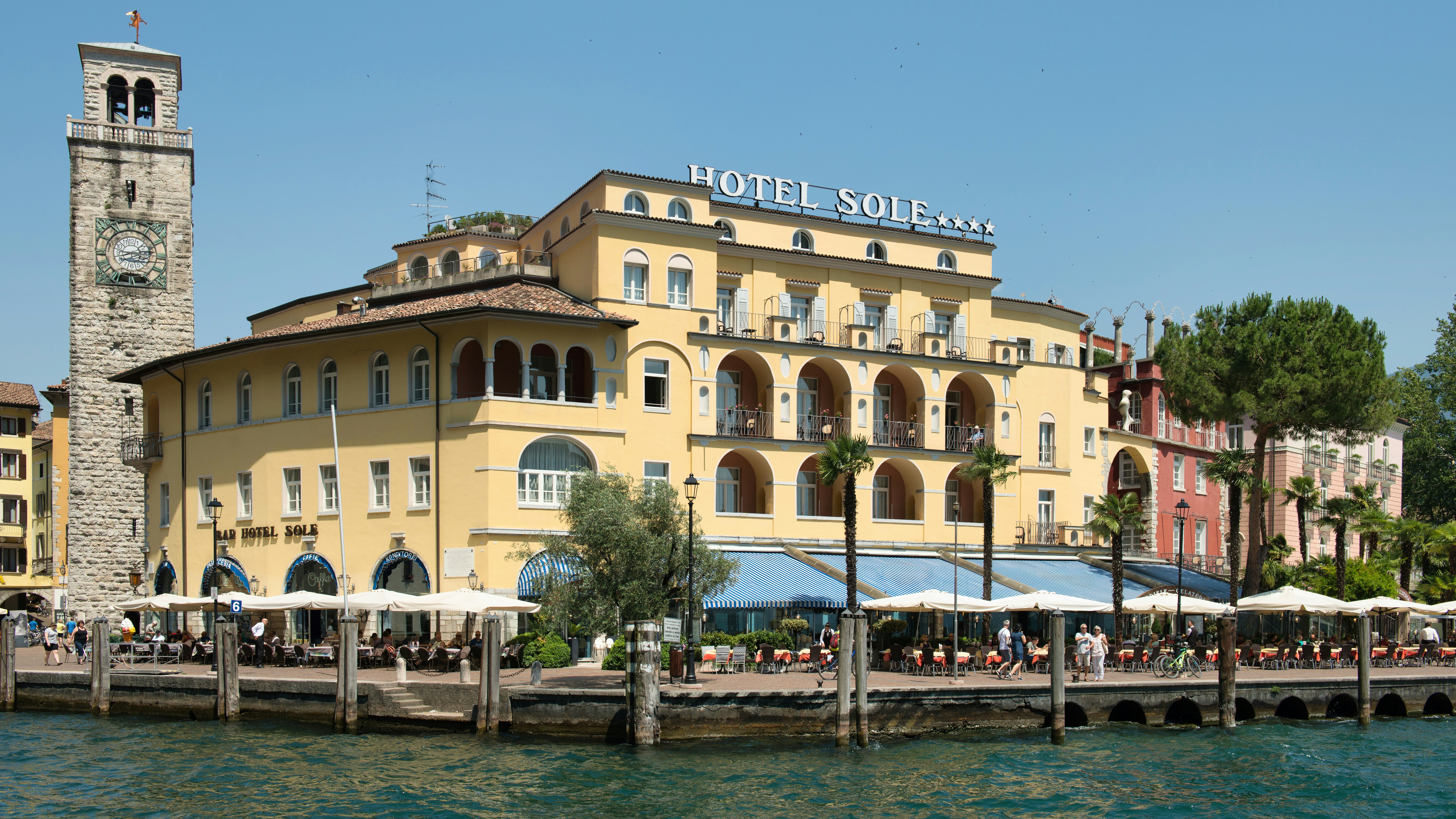Yellow hotel building with clock tower by the water