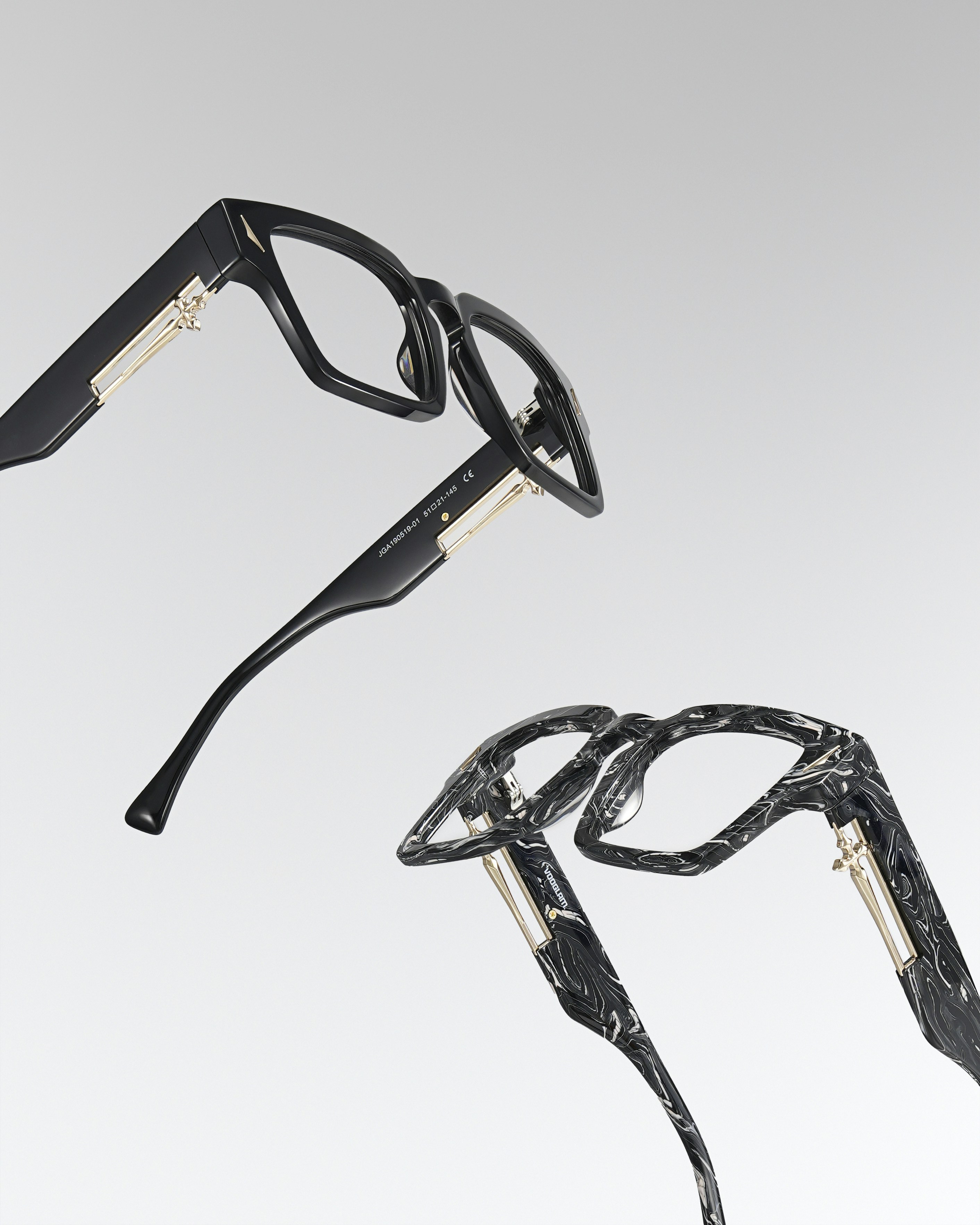 Two pairs of stylish eyeglasses on a light background