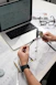 Hands measuring eyeglasses with calipers on desk