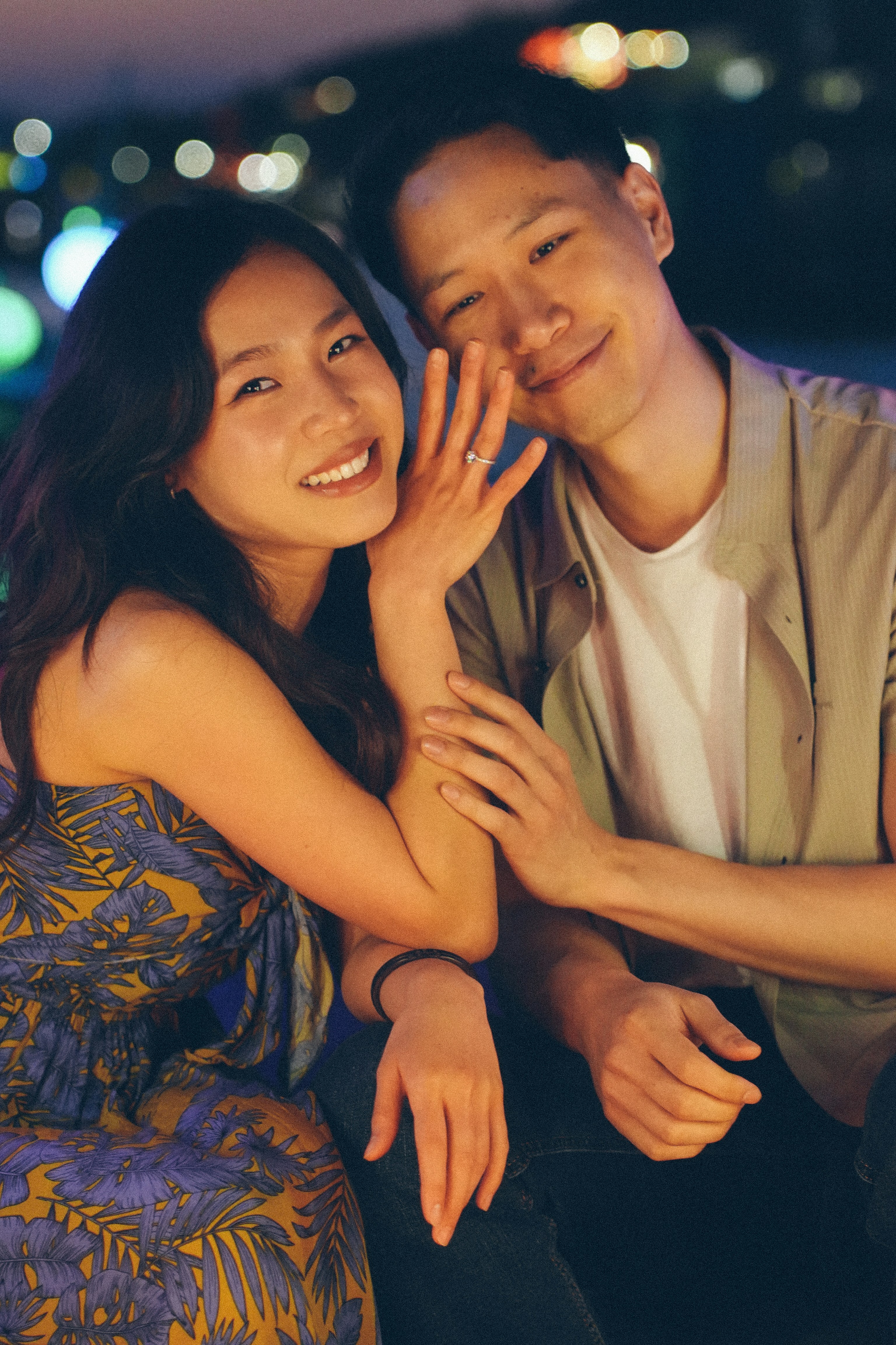 Couple smiling with engagement ring visible