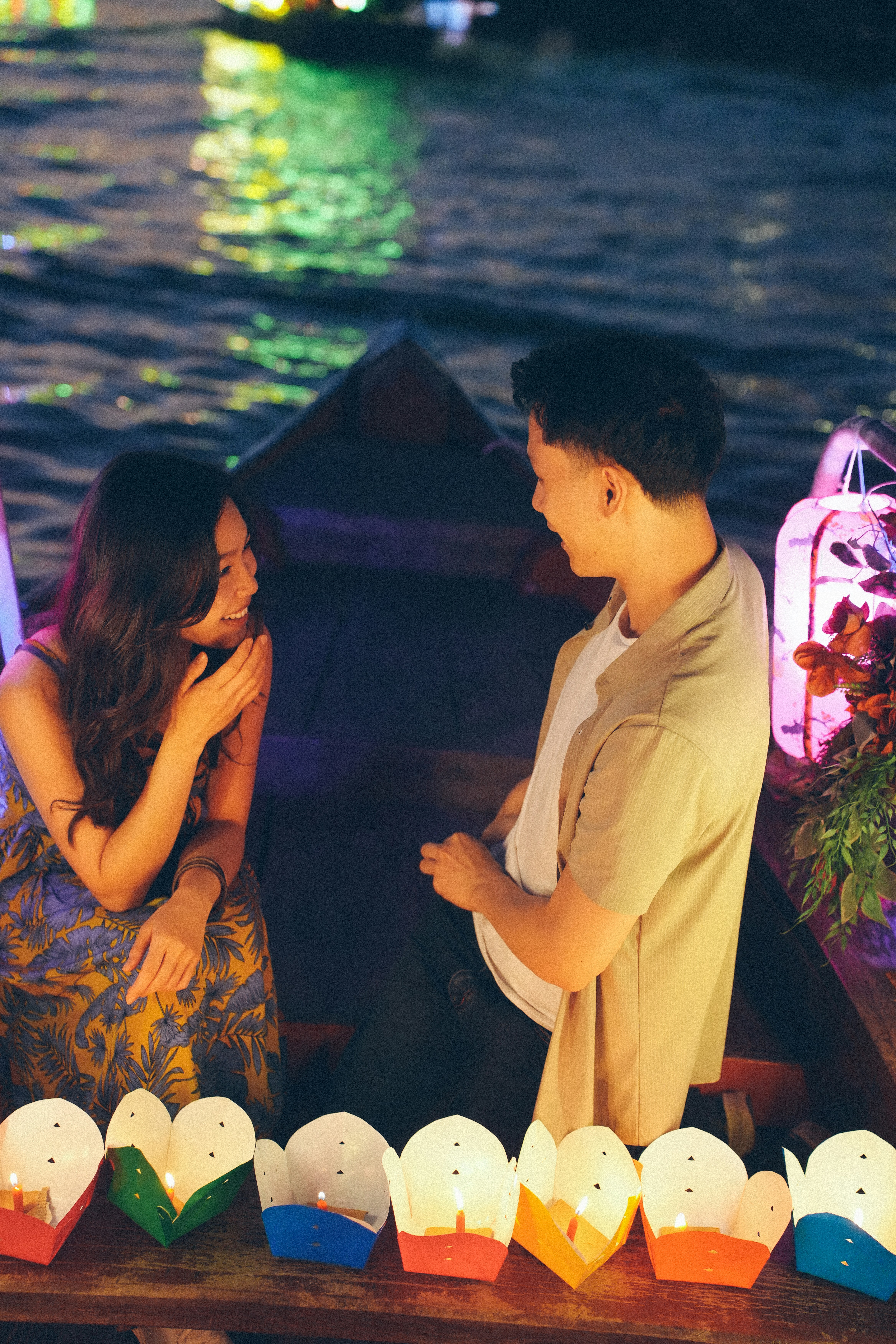 Paar nachts im Boot mit Laternen