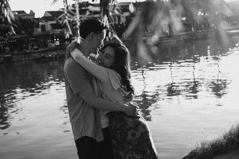 HSV-positive couple embracing at sunset by water