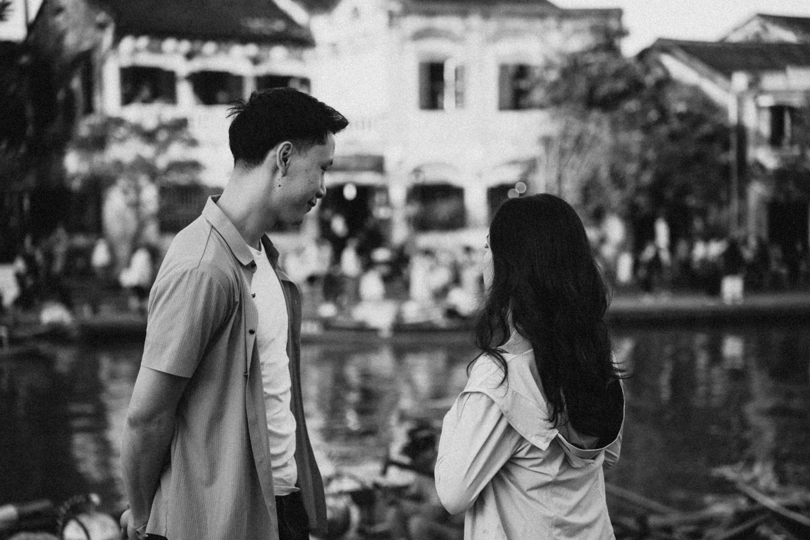 川辺で向き合って話すカップル