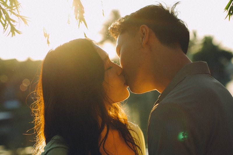 Couple kissing during golden hour with sun flare