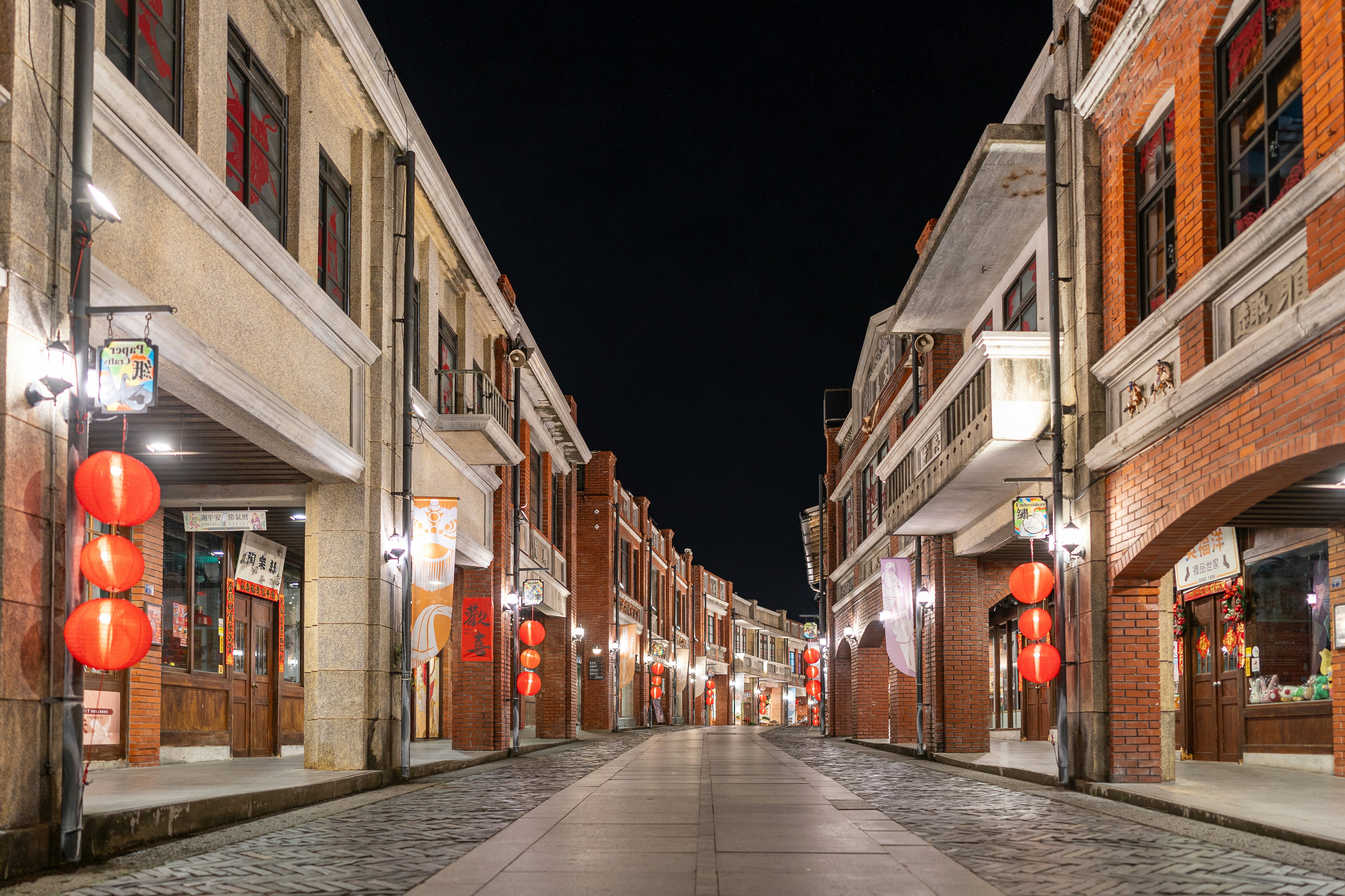 Empty street lined with traditional buildings at night.